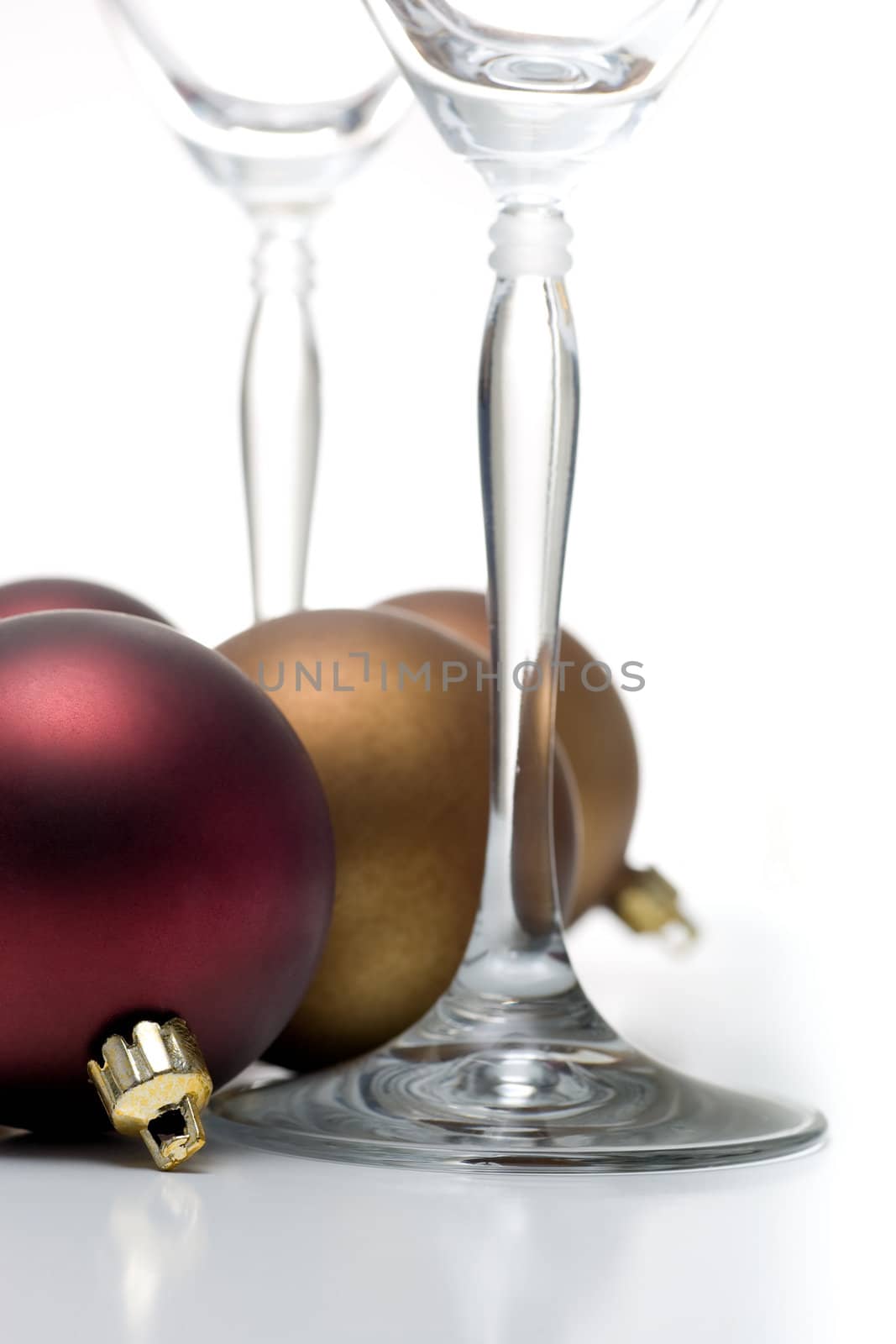 Champagne glasses surrounded by christmas ornaments, isolated on white.