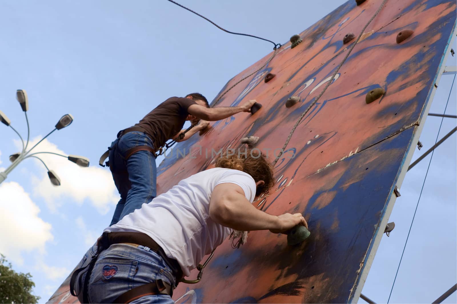Two people taking part in climbing competition during the beer festival in Moscow