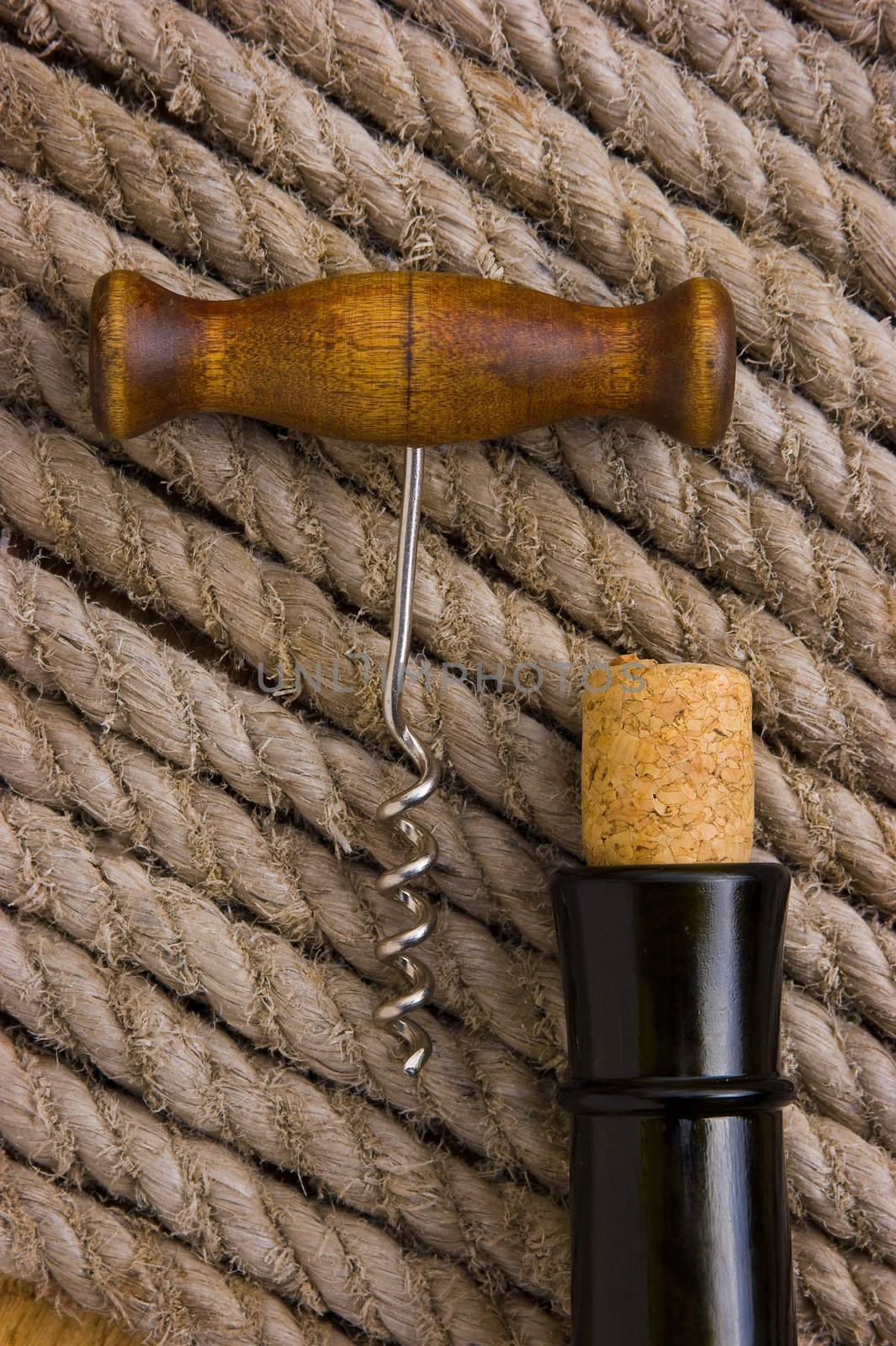 corkscrew with a cork and bottle on the background of the rope