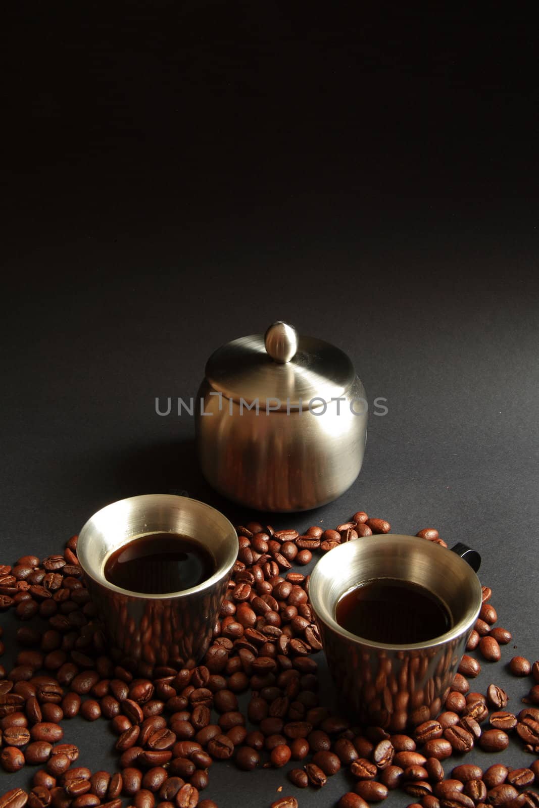 Coffee in metal cup with roasted beans