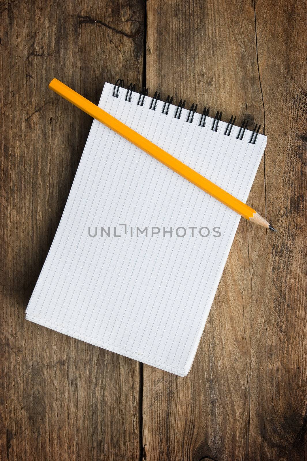 Notepad and pencil on the background of the wooden planks by oleg_zhukov