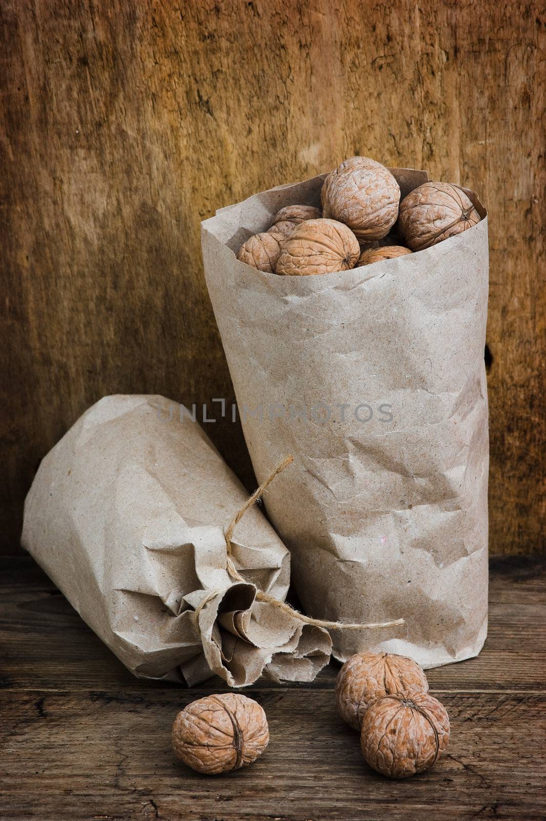 Walnuts in paper bags on the background of an old wooden board