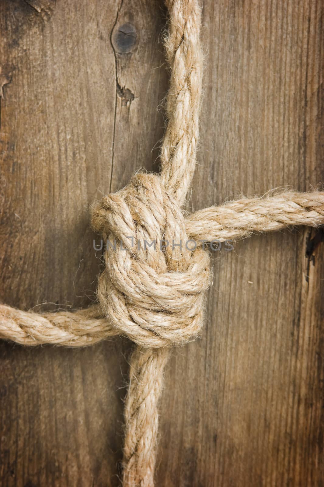 Rope with knots on the background of the old wooden boards