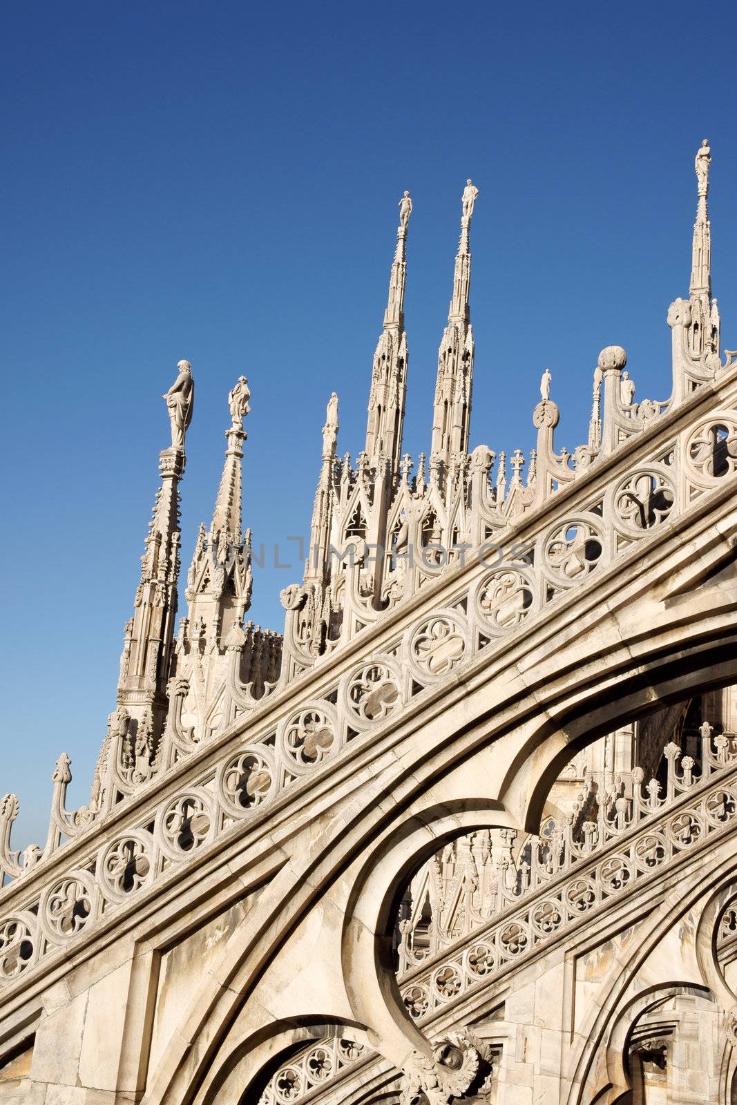 Detail of the gothic Milan Cathedral in Piazza del Duomo. It is the fourth largest church in the world. The construction started in 1386 and took about five centuries. This detail was taken from the roof and refers to the upper left side of the Cathedral.