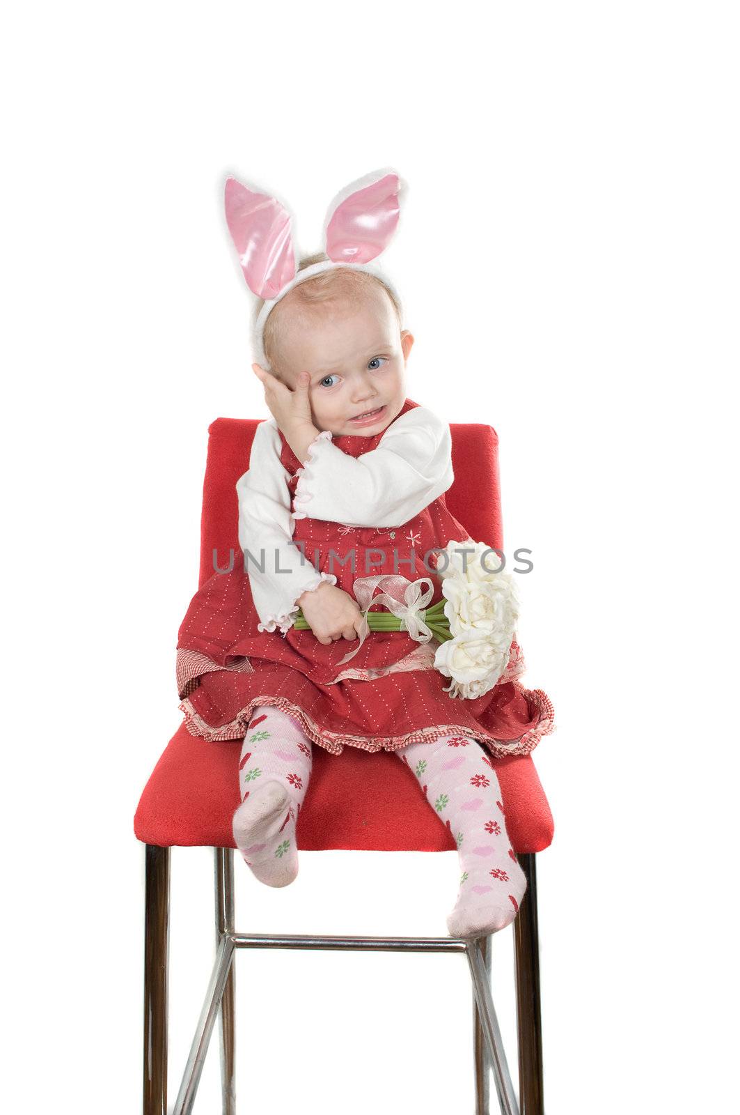 Closeup portrait of little girl with hare ears sitting on the chair