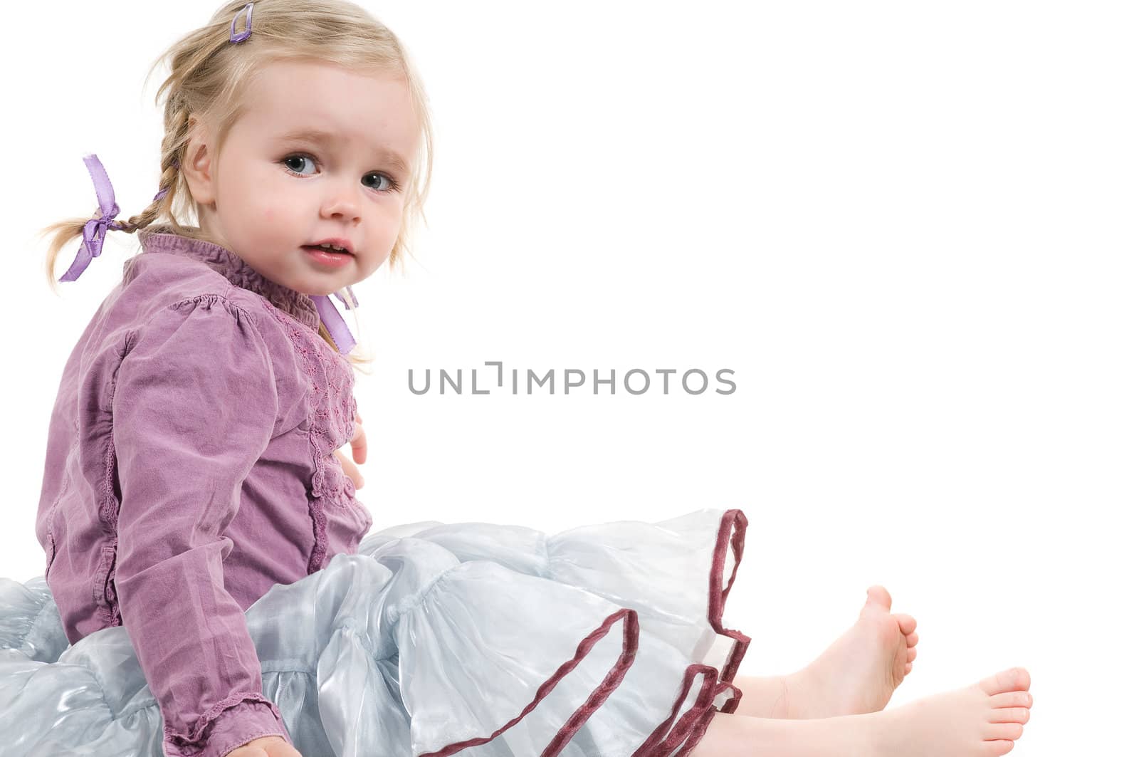 A little girl sitting on the floor in studio