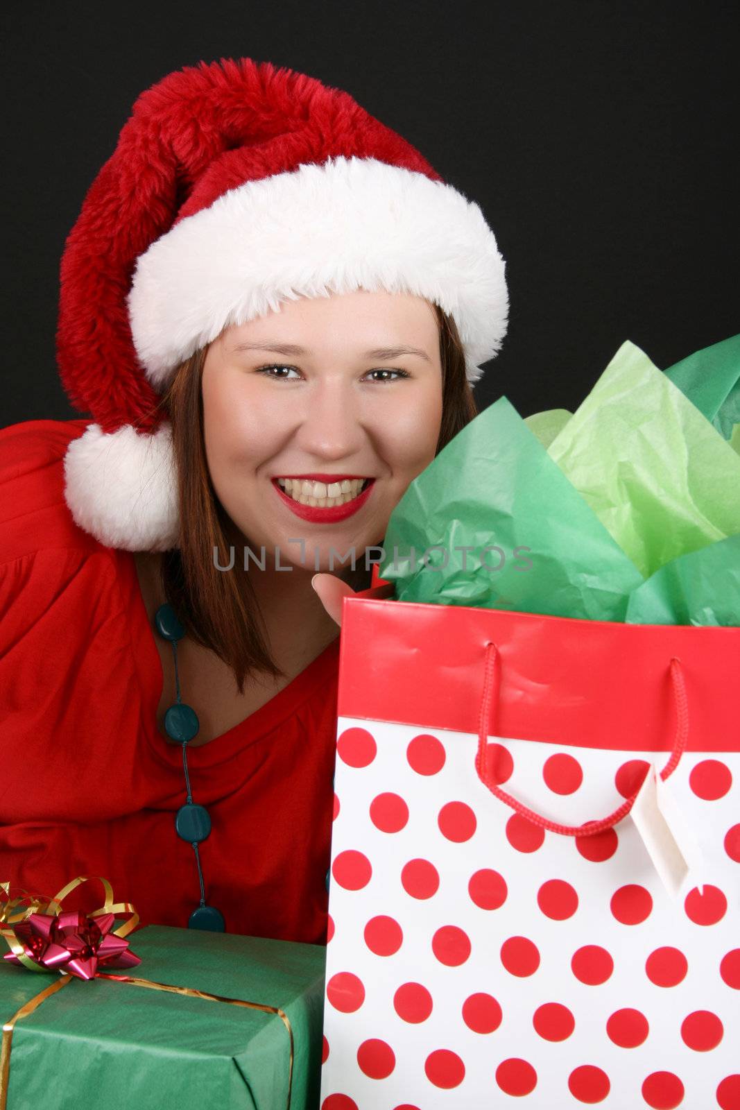 Beautiful brunette female with christmas gifts wearing a fluffy hat
