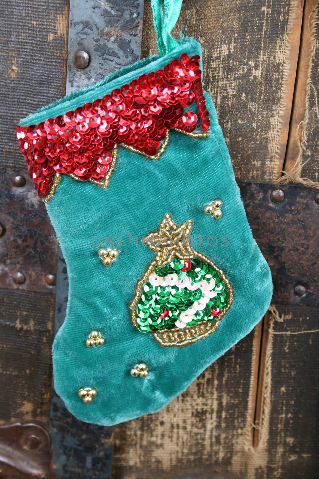 Small Christmas stocking against an antique wooden trunk
