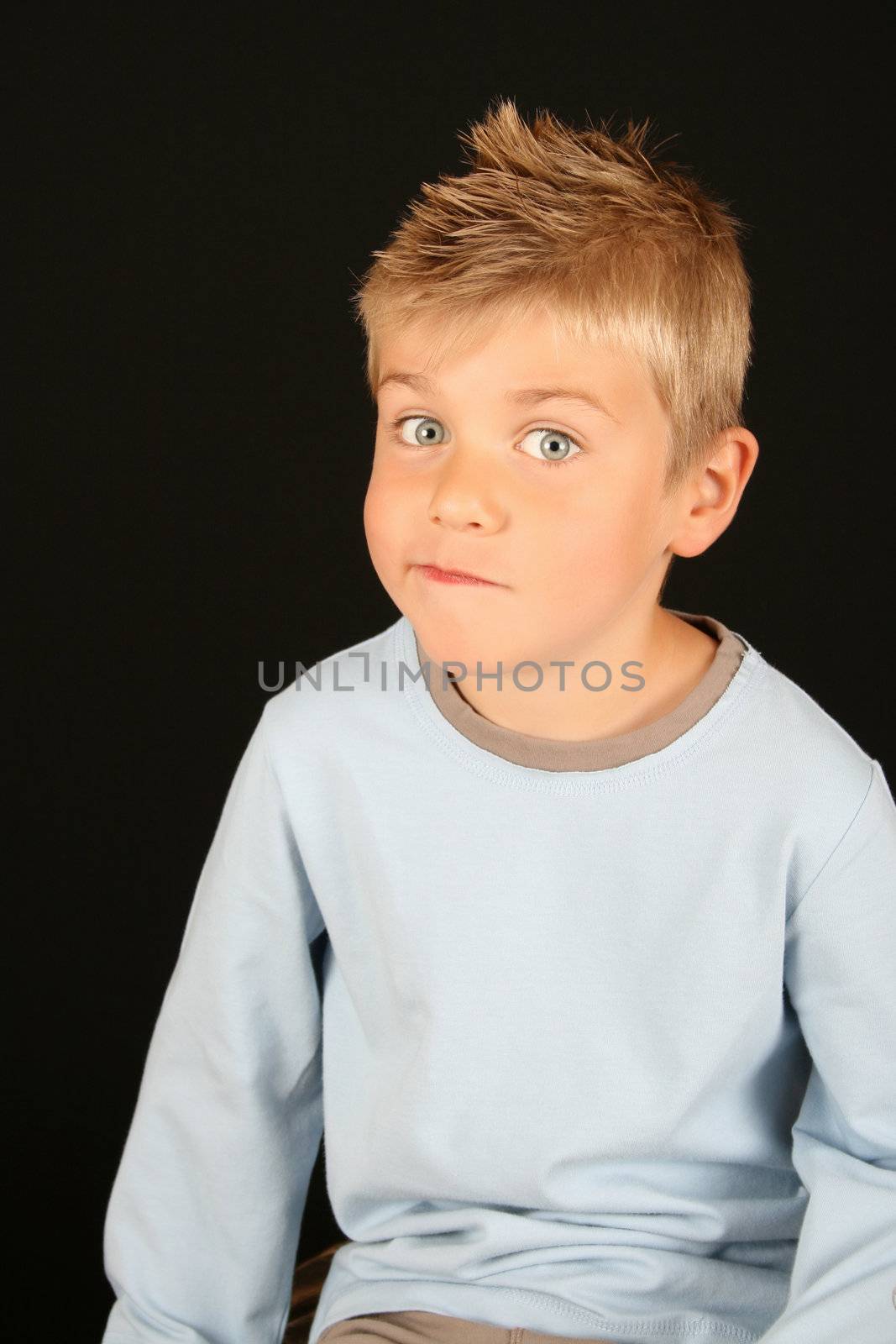 Cute blond boy on a black background