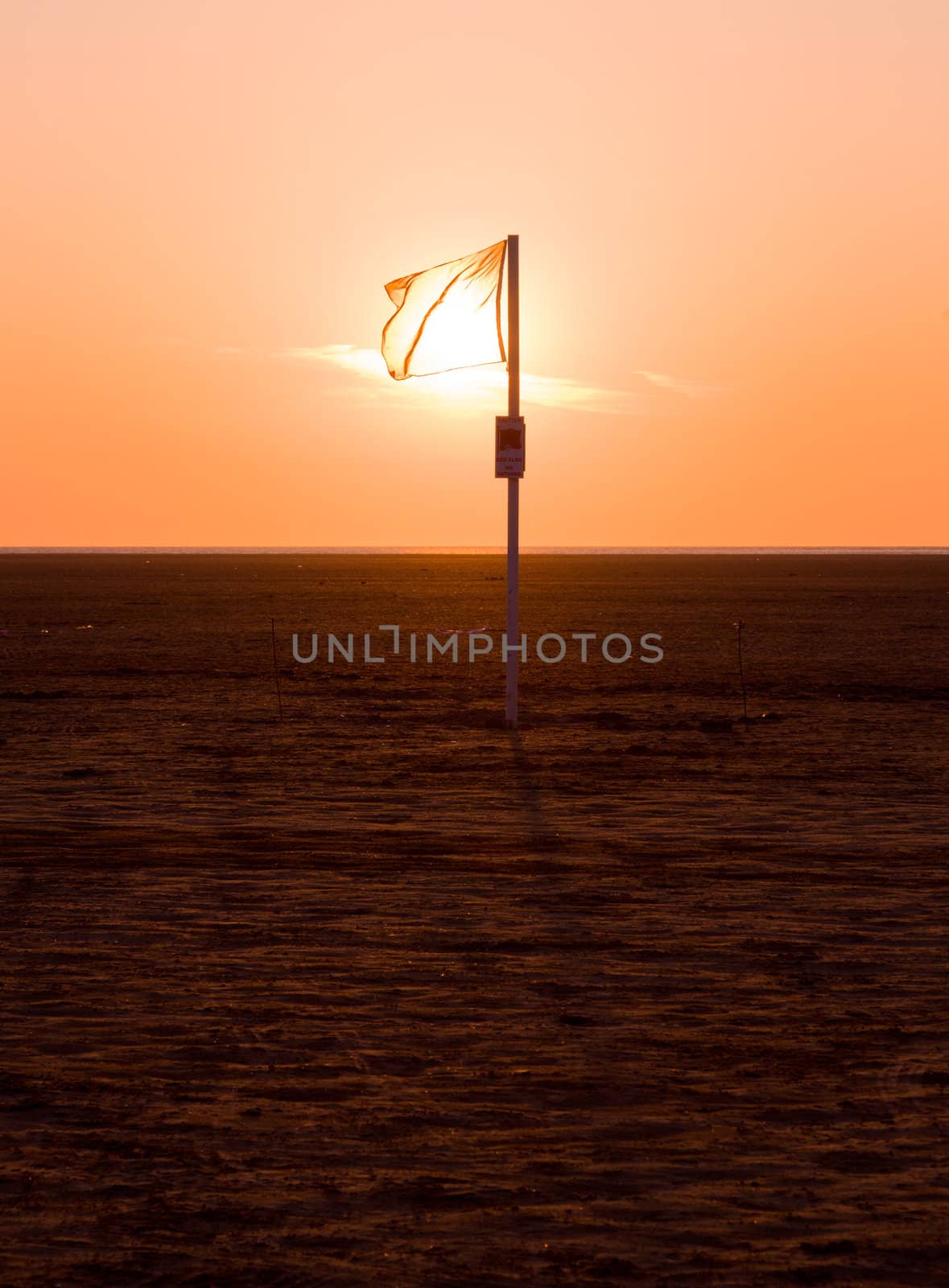 No swimming sign at sunset with no sign of the sea - acreas of sand on Southport beach