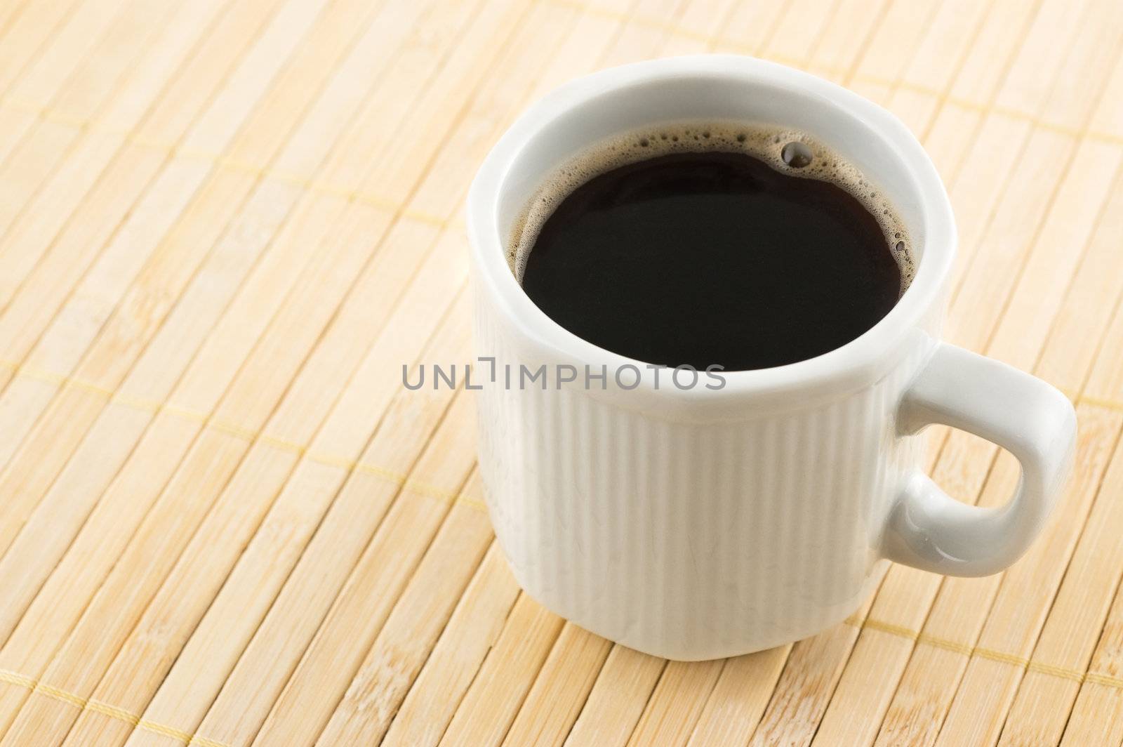 Coffee cup on a bamboo mat, close up shot.