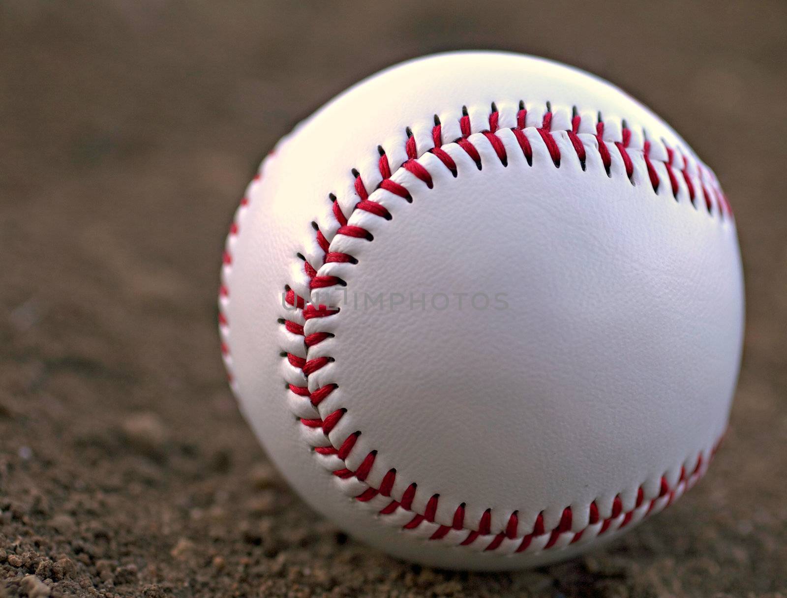 Closeup of a Baseball Sitting in Infield Dirt