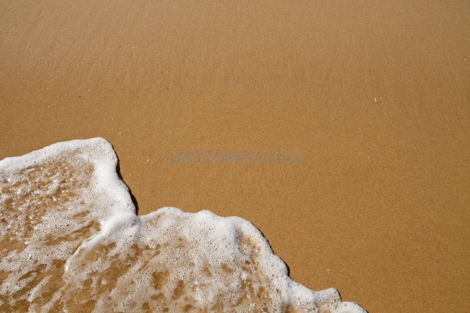 Wave over sand - with upper copy space