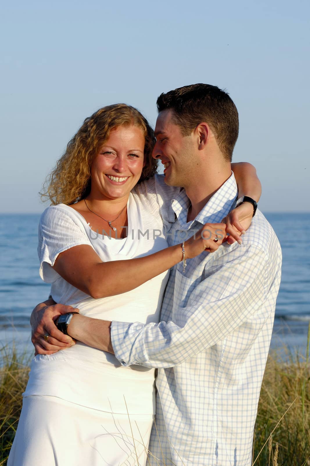 Happy young couple at beach by cfoto