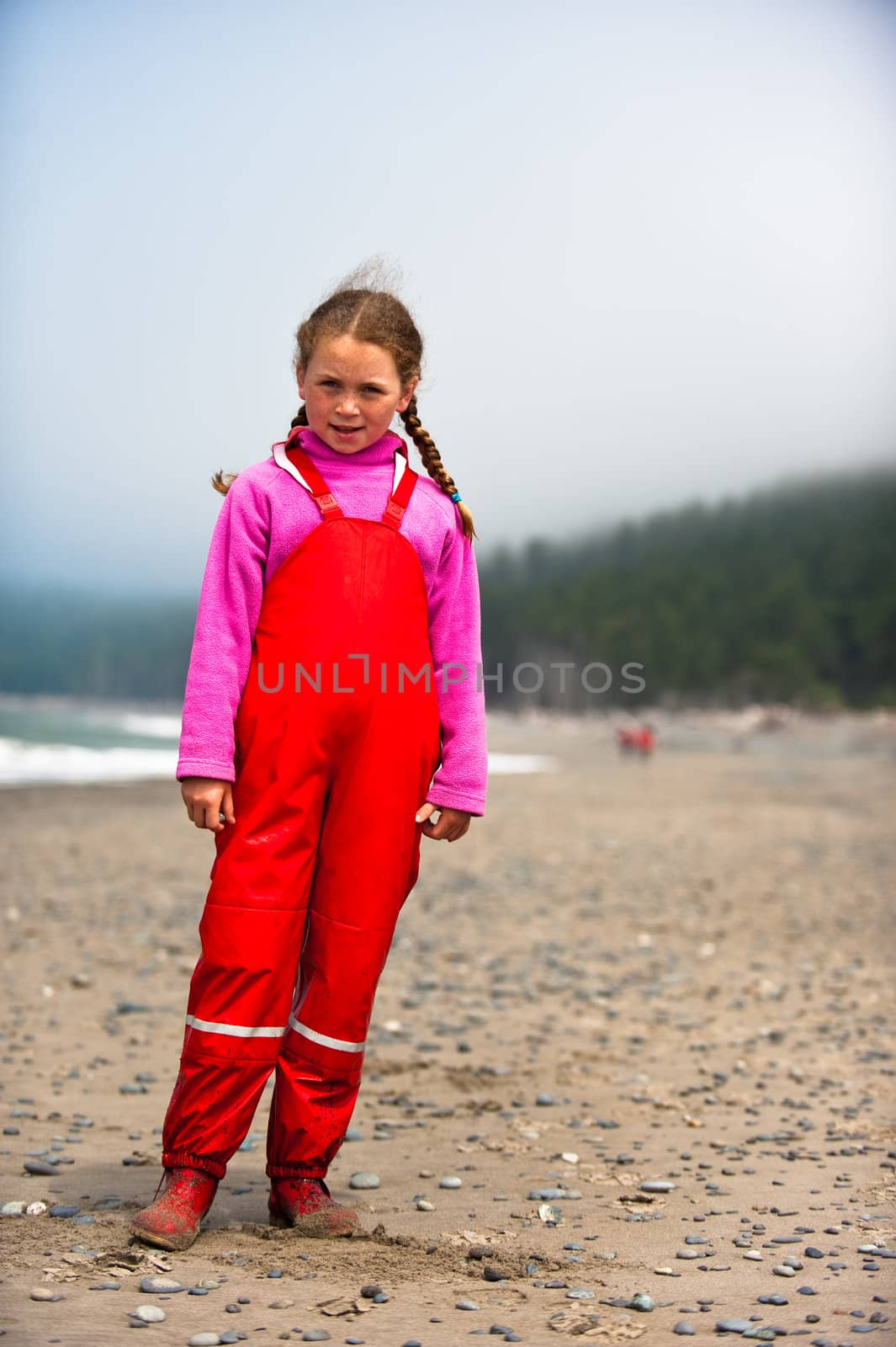 young girl in red rain clothes on ocean beach, Washngton, USA by rongreer