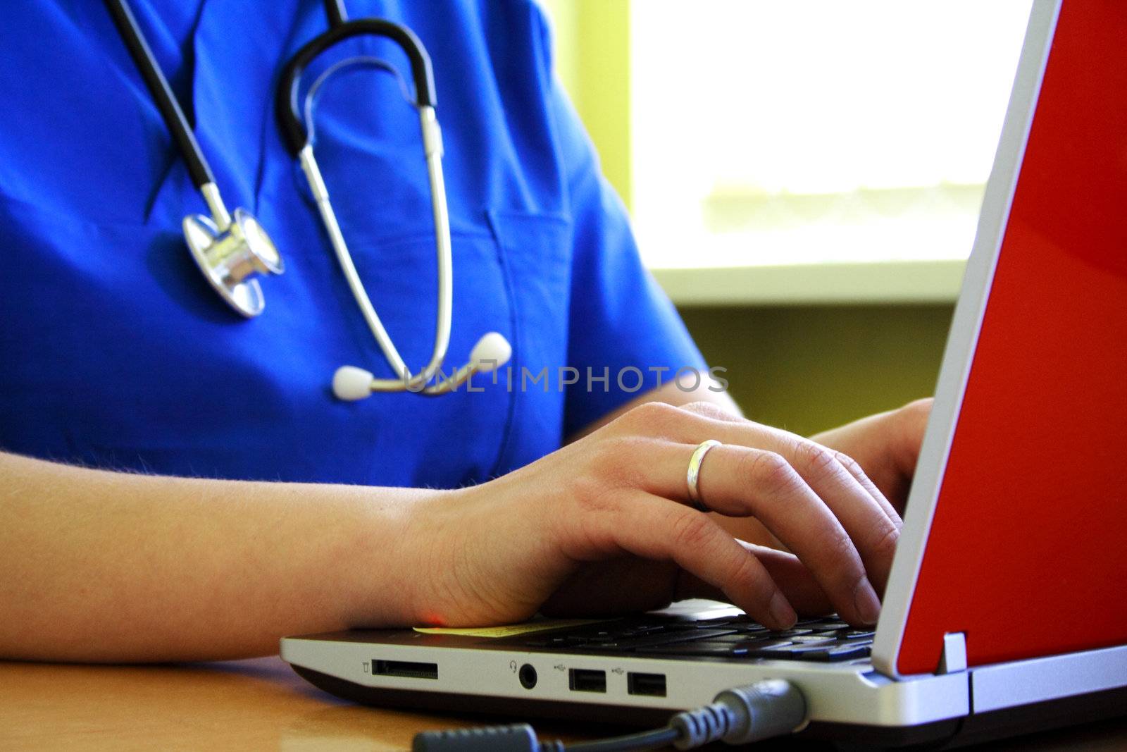 Doctor sitting at his desk with laptop computer