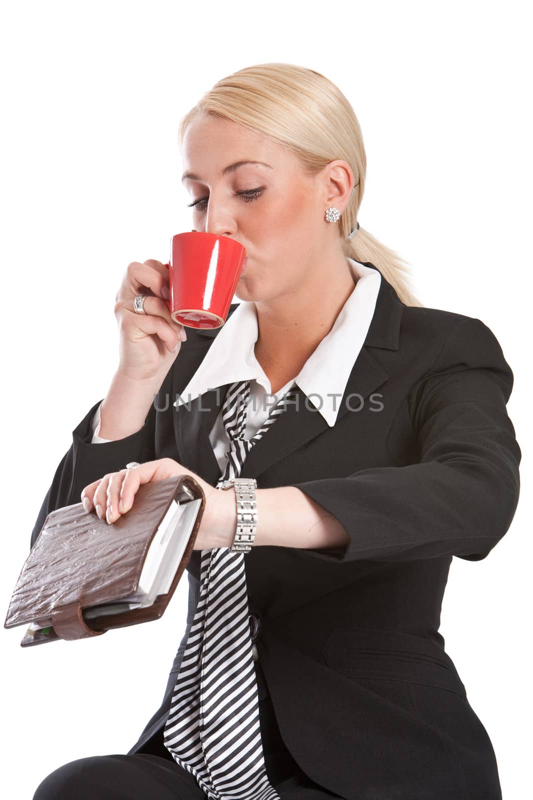 Attractive businesswoman checking her watch while drinking her coffee