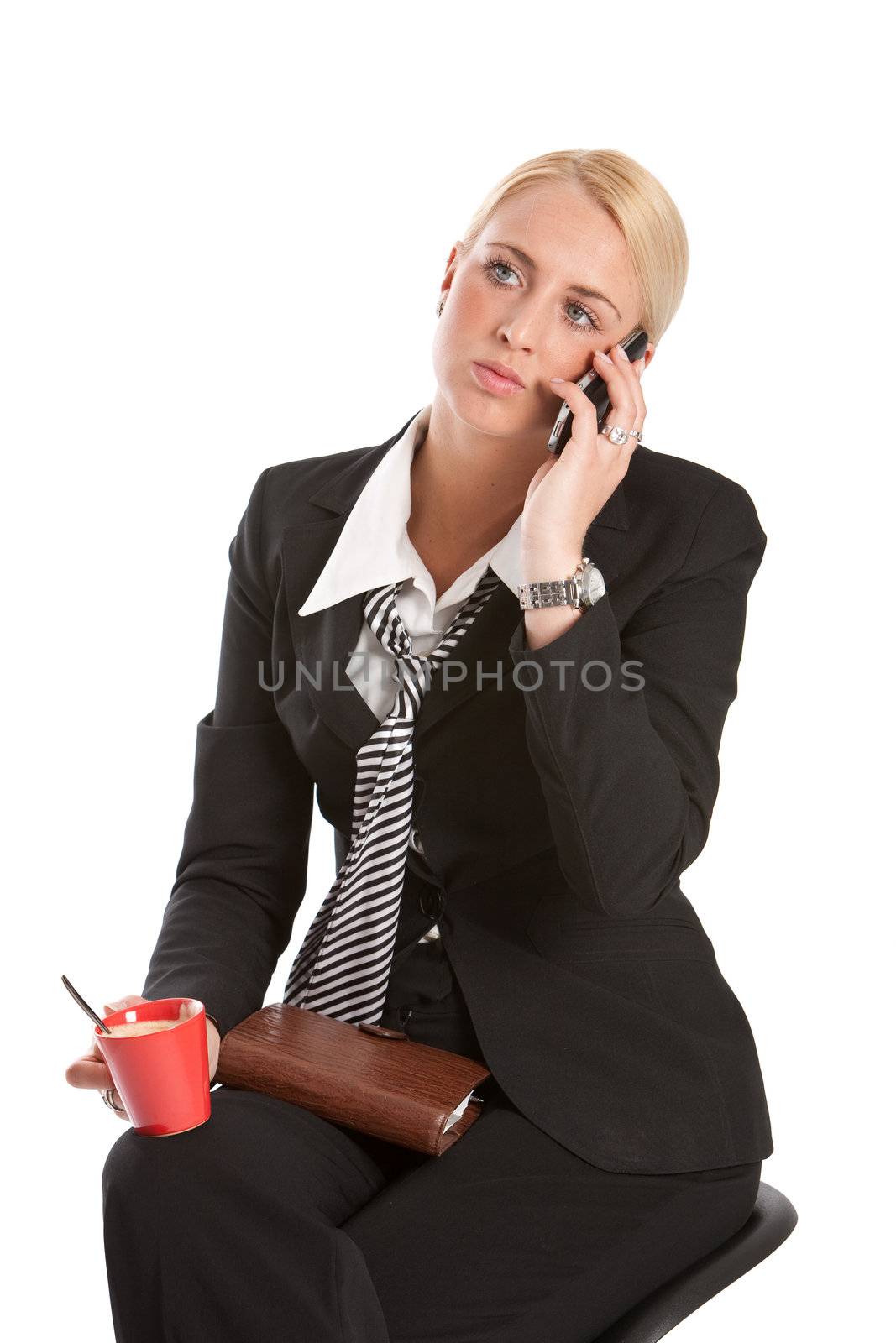 Attractive young business woman sitting and listening to the phone