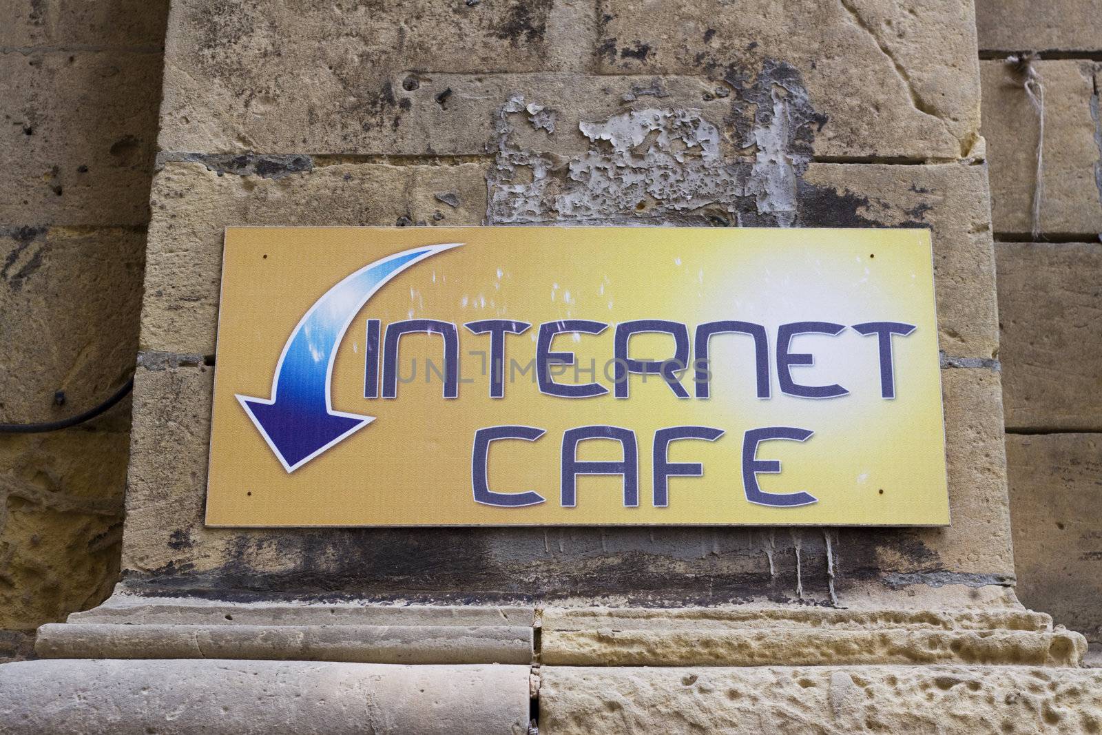 A sign with an arrow showing the way to an internet cafe
