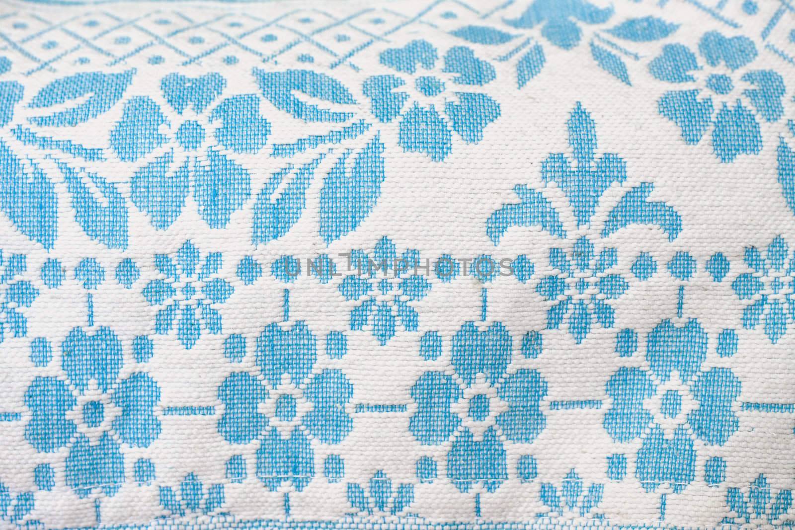 Detail of a vintage woven wool fabric, blue flowers on white background
