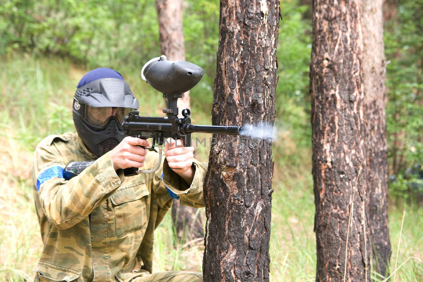 Paintball player shooting in the forest