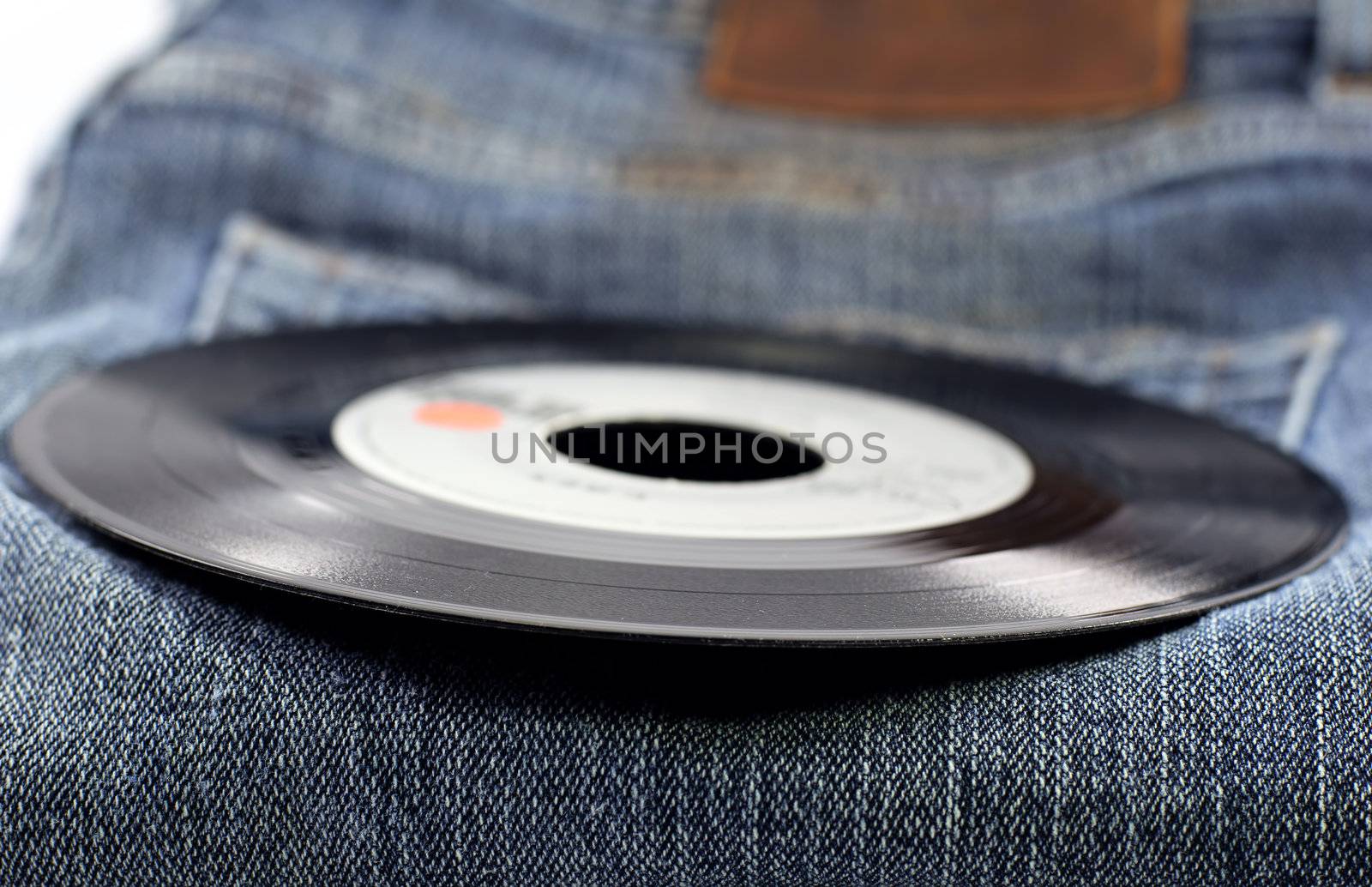 a vinyl record on a pair of jeans