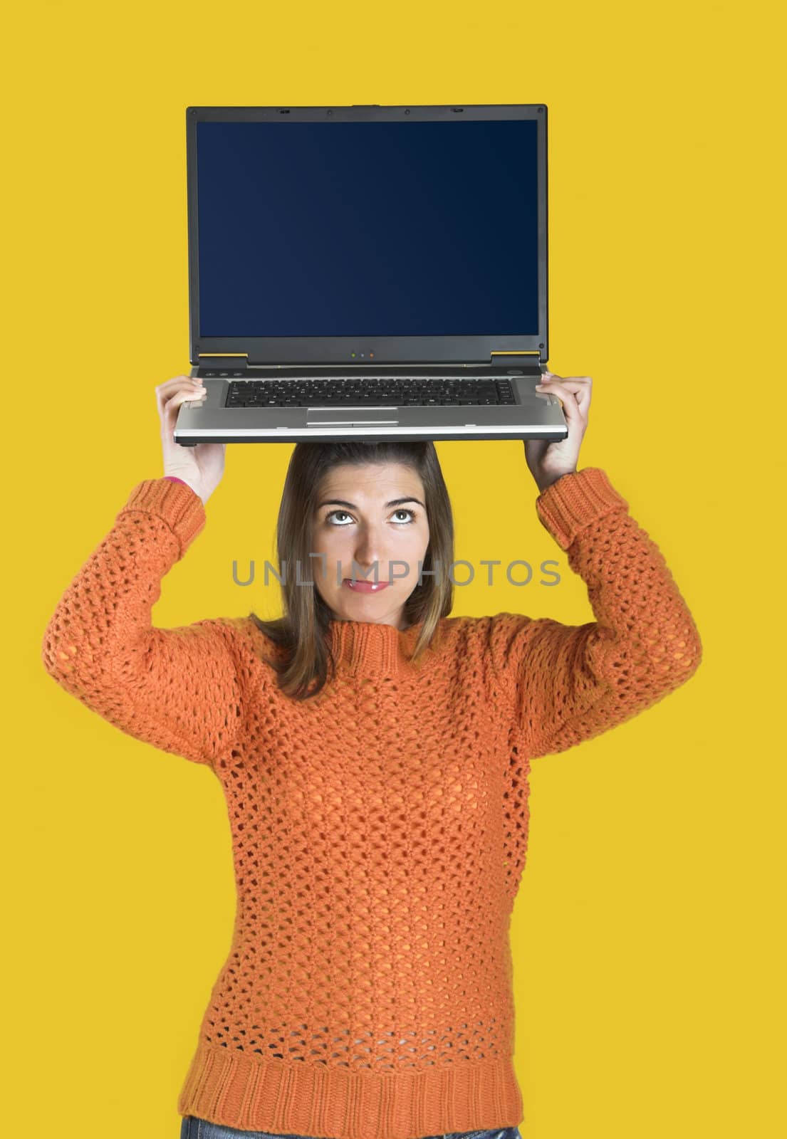Beautiful student woman with a laptop over a yellow background
