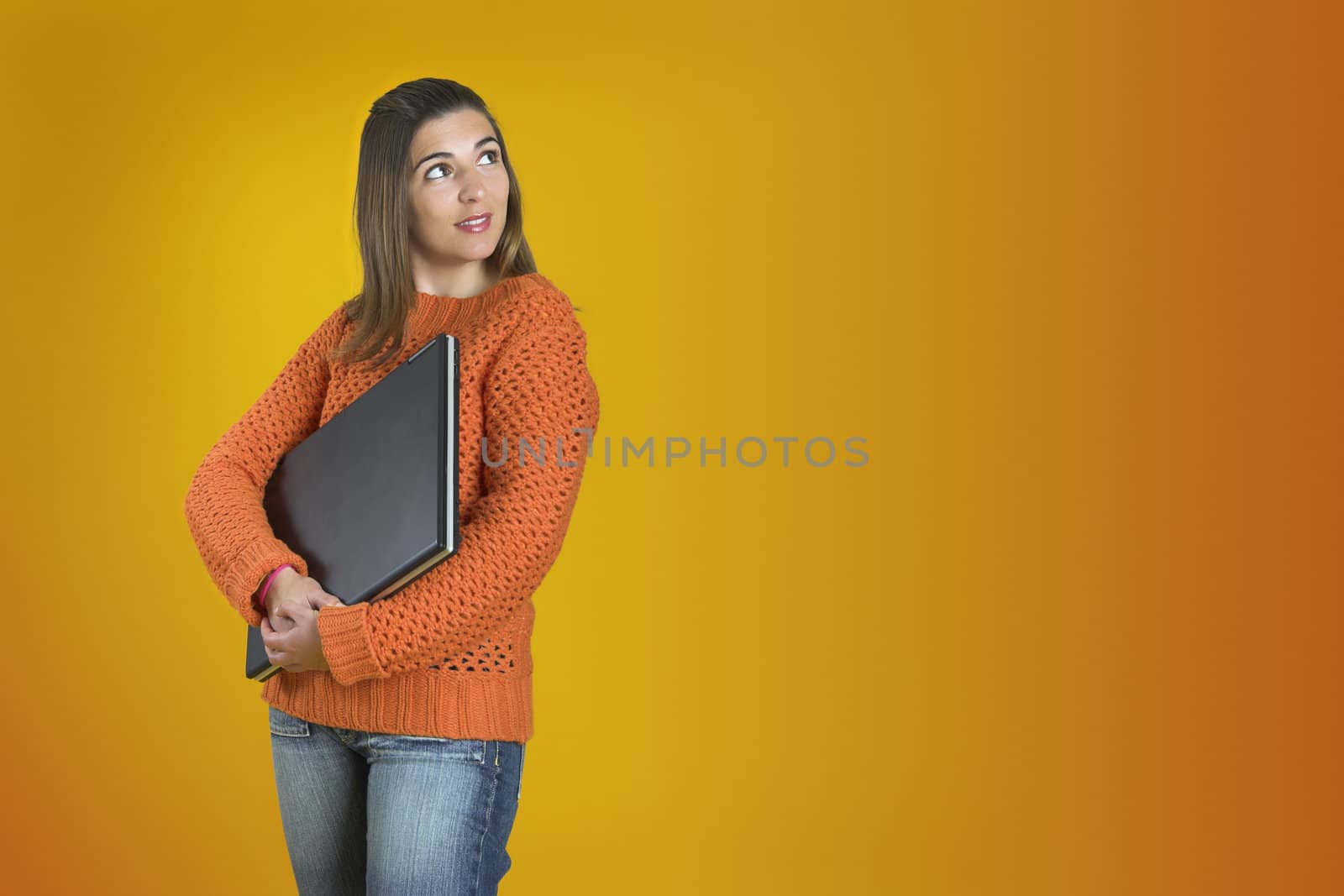 Beautiful student woman with a laptop over a yellow background