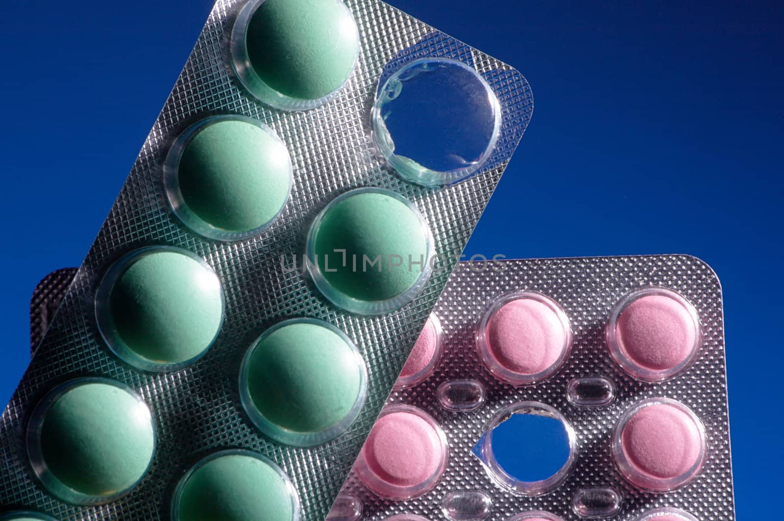 Pink and green tablets on a dark blue background