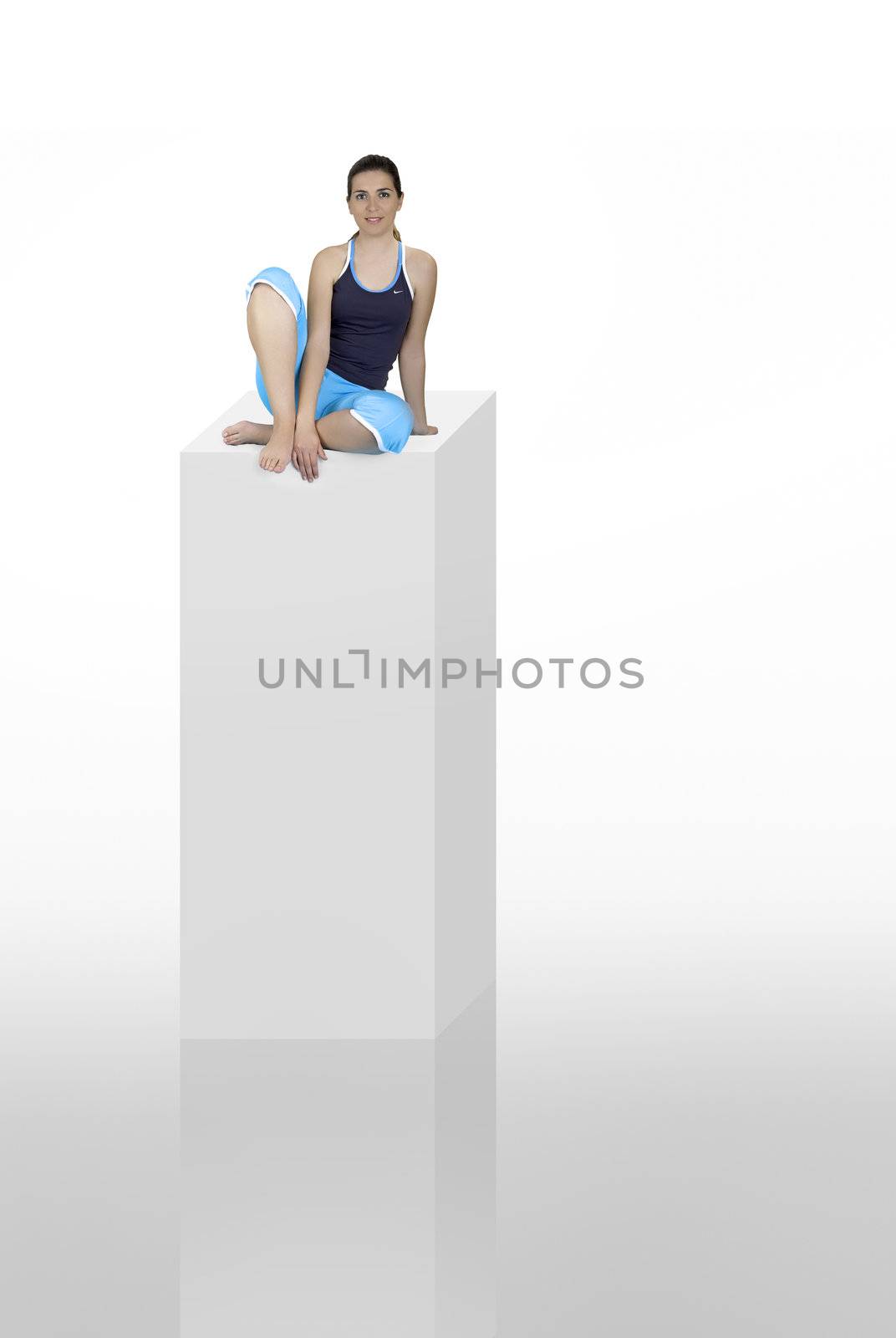 Beautiful athletic woman seated on a high column