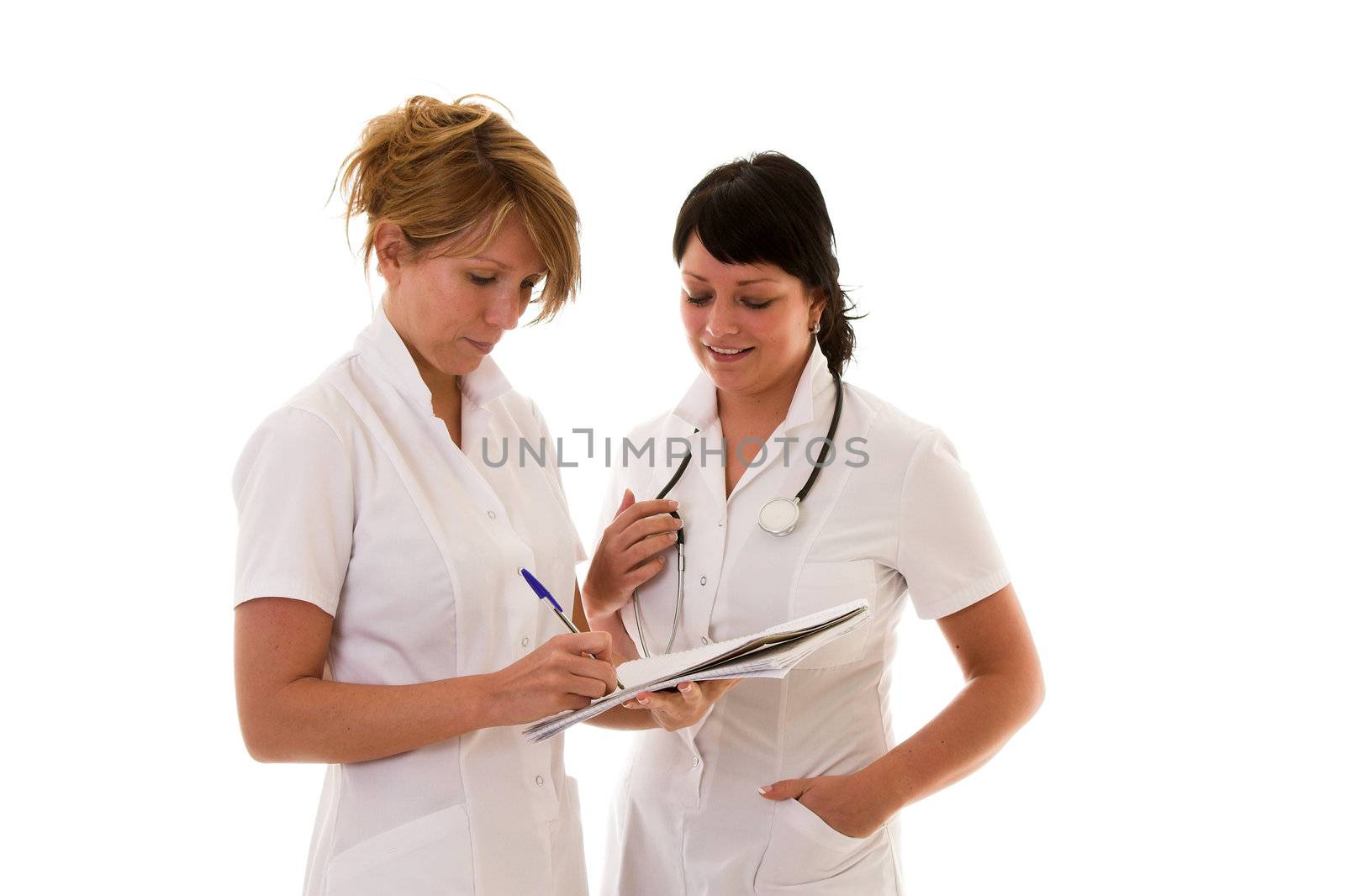 Two nurses standing together discussing patients