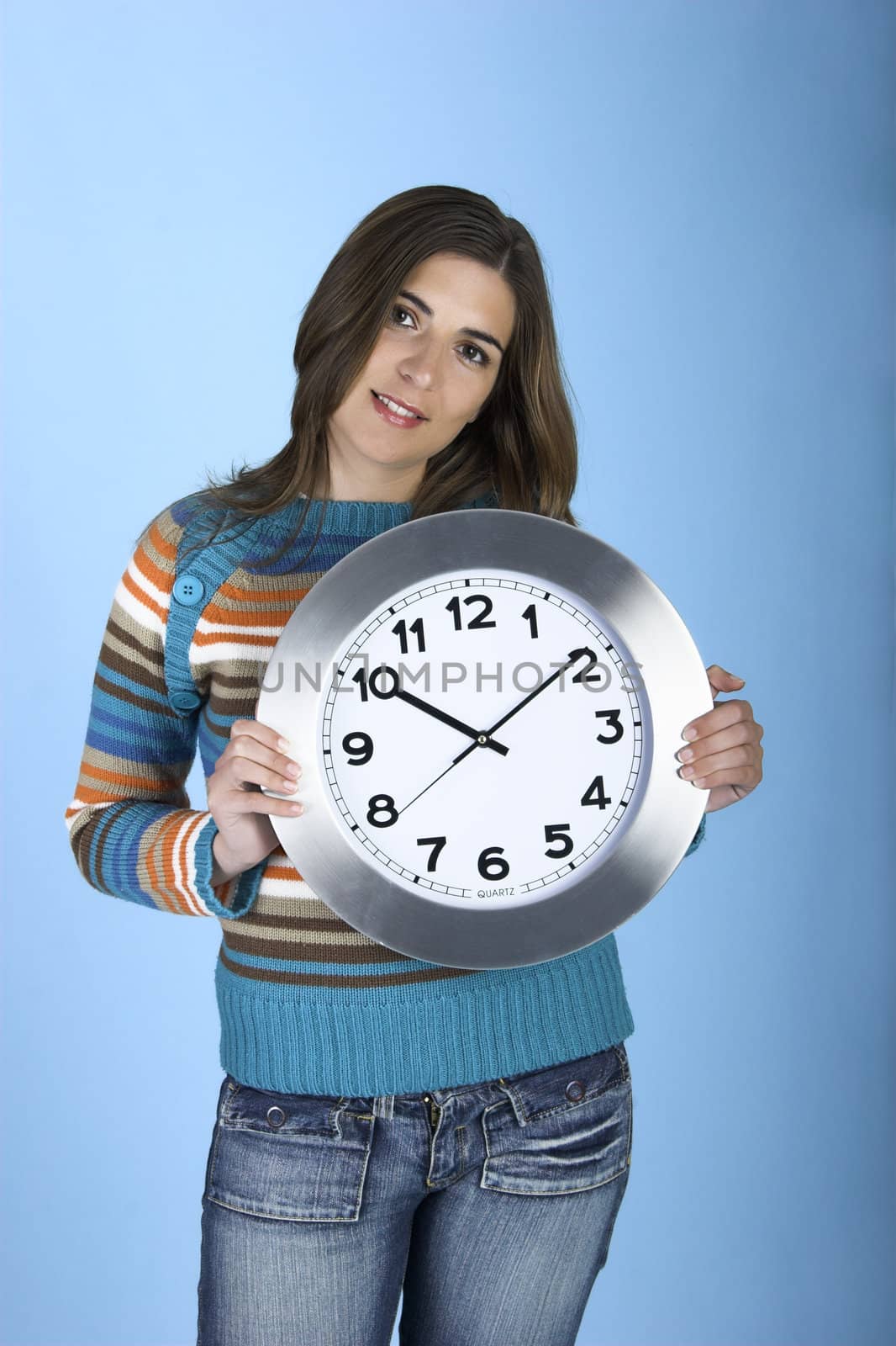 Woman holding a clock on a blue background