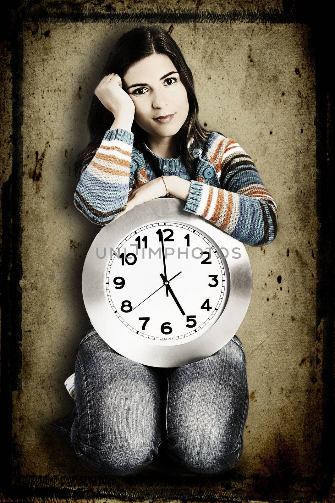 Beautiful women over knees holding a big clock with a grunge background on the back (manilpulated in PS)