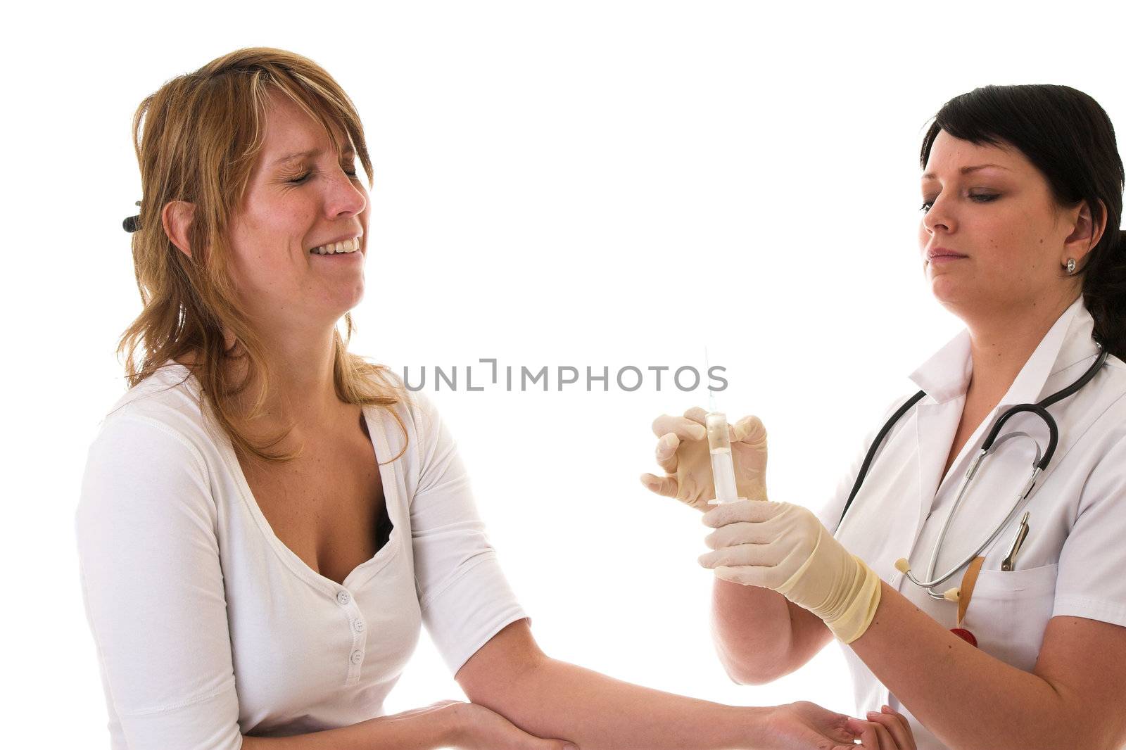 Female patient closing her eyes out of fear for the needle and syringe that the nurse is holding ready to give her an injection
