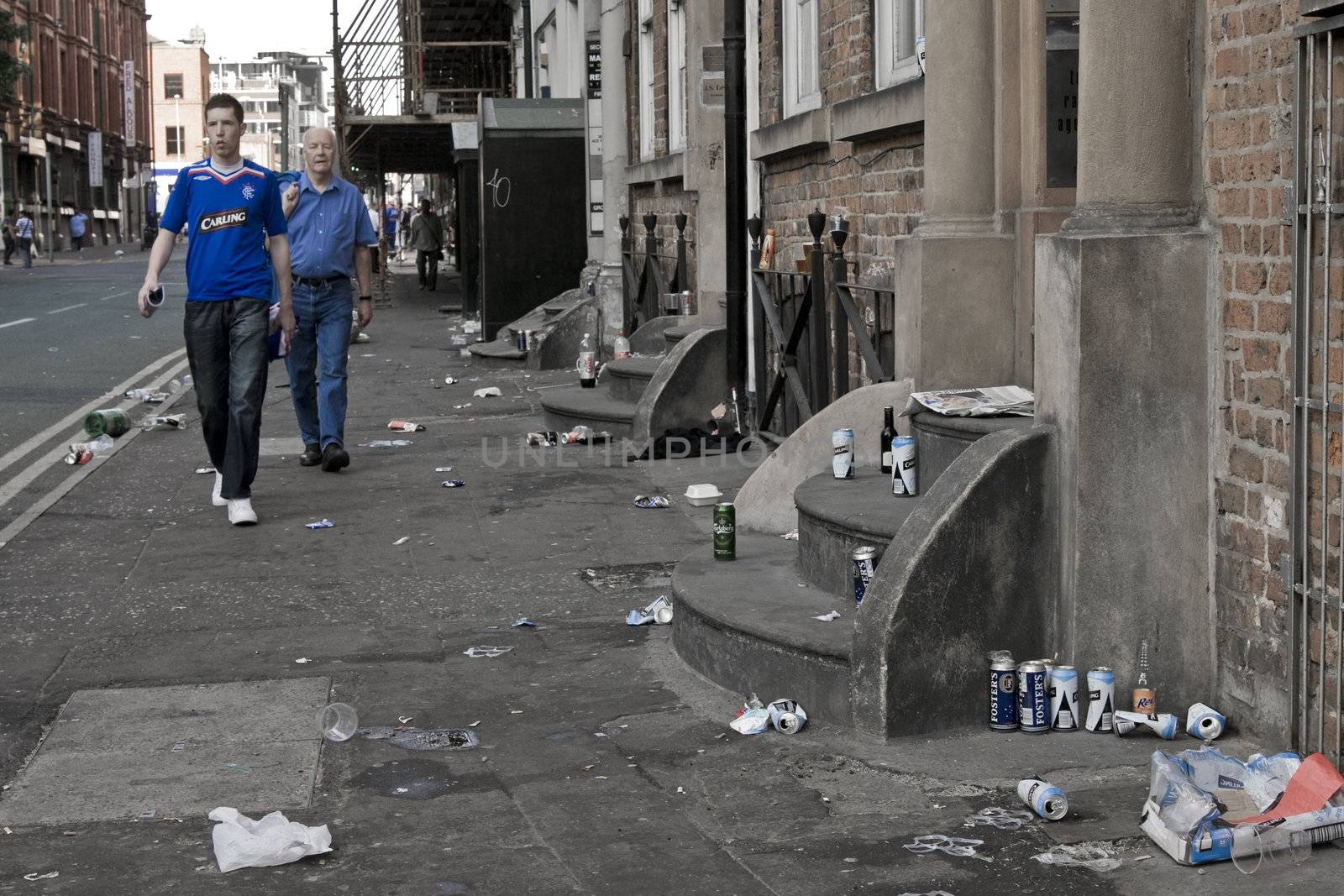 Rangers fan walking in a street littered with rubbish before the UEFA cup 2008