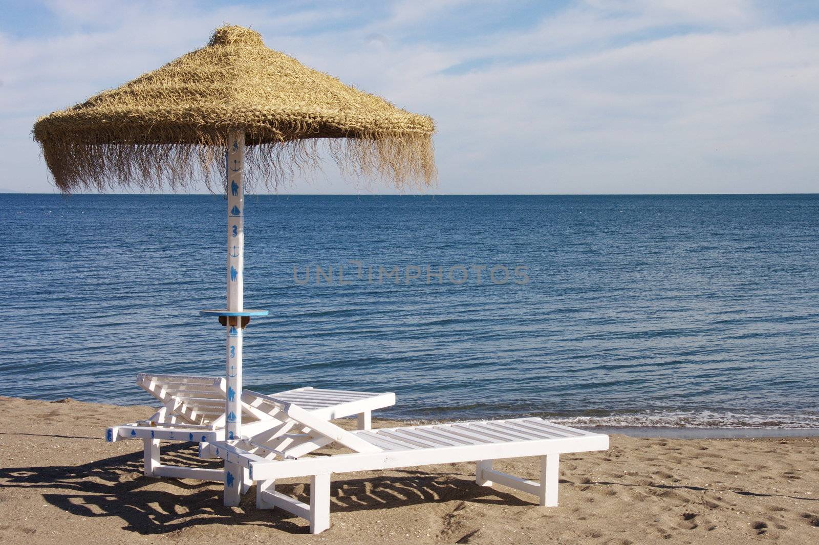 sunbeds and parasols set out on a sandy beach