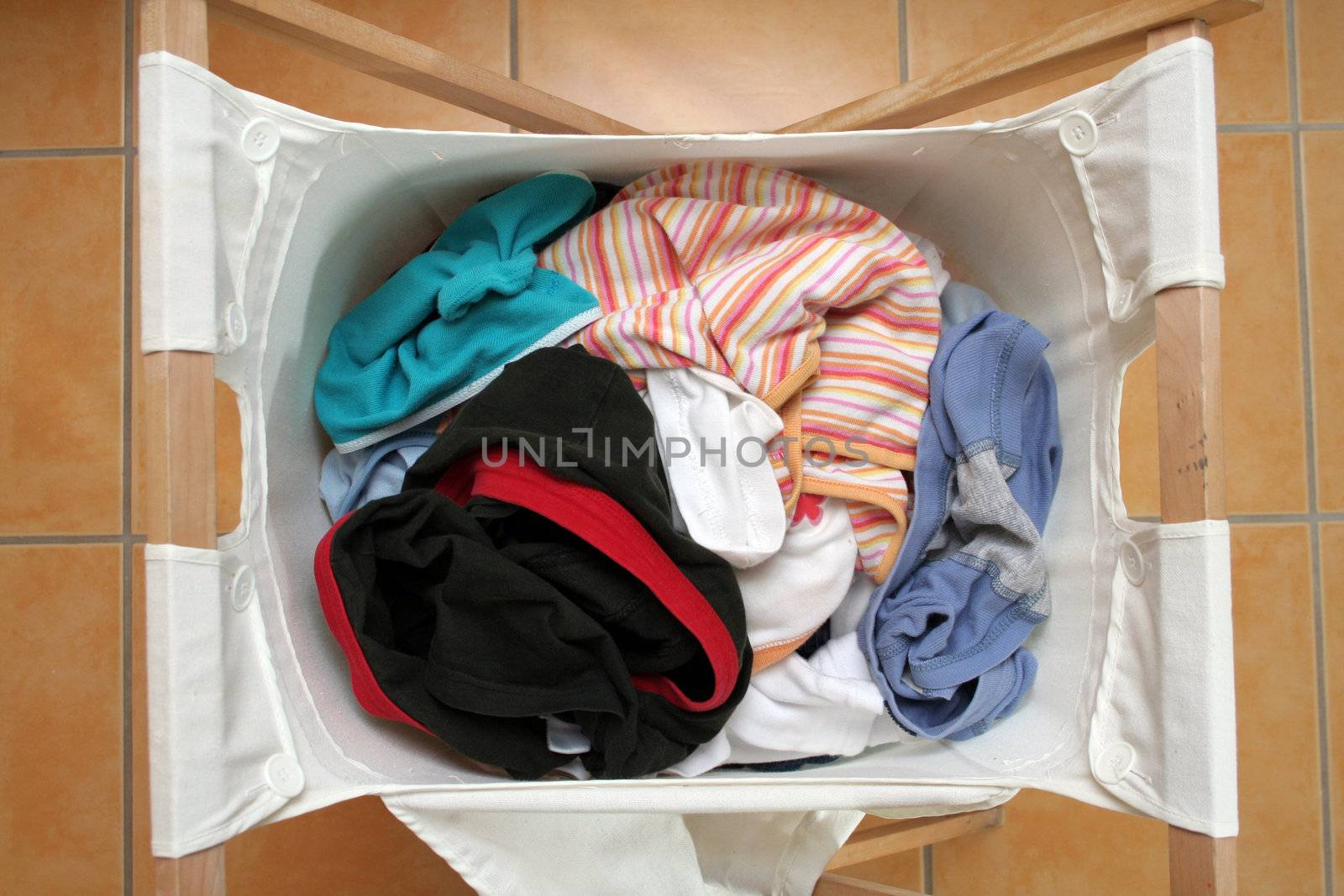 dirty clothes in a wooden loundry basket