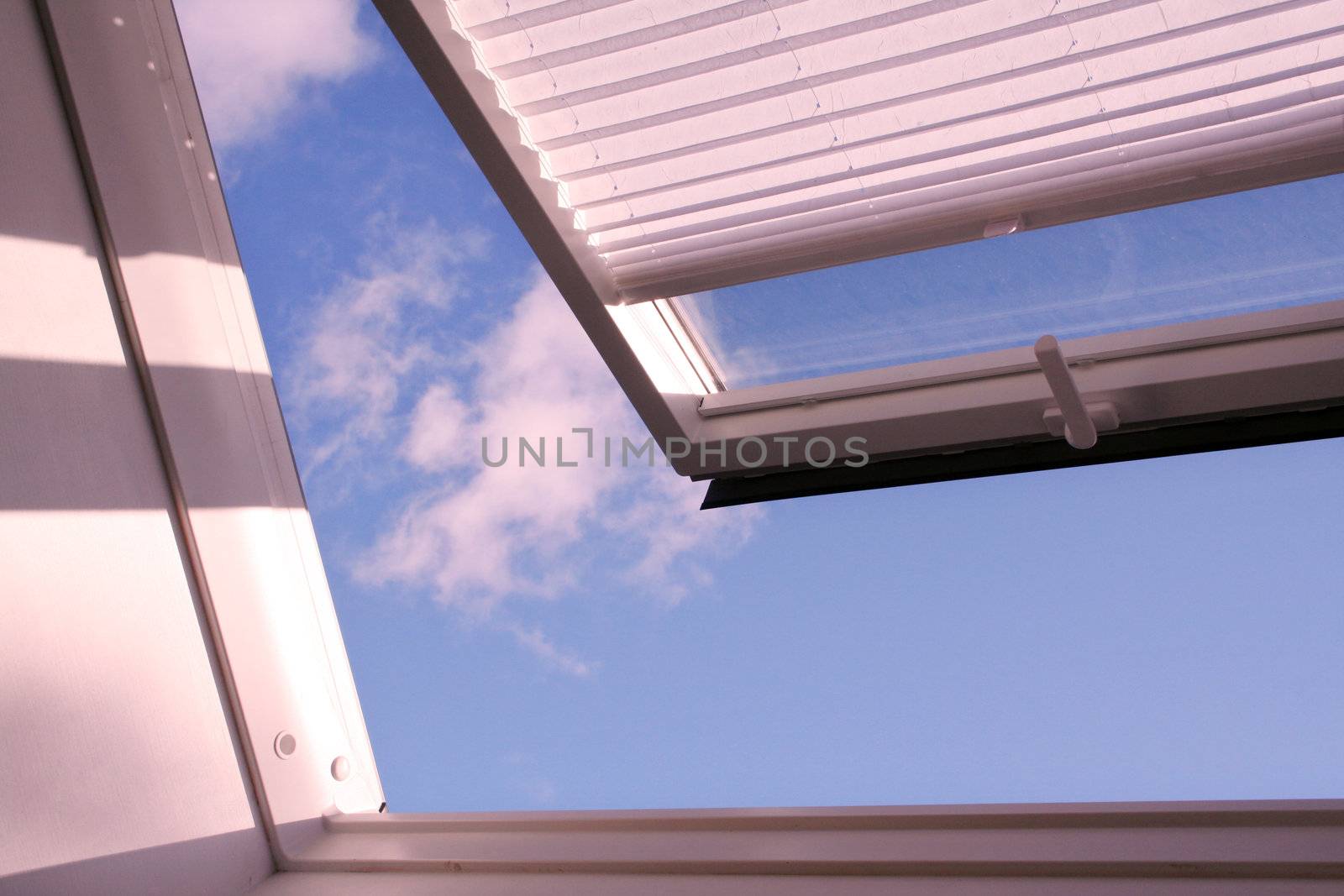 opened roof window with shutter and clouds