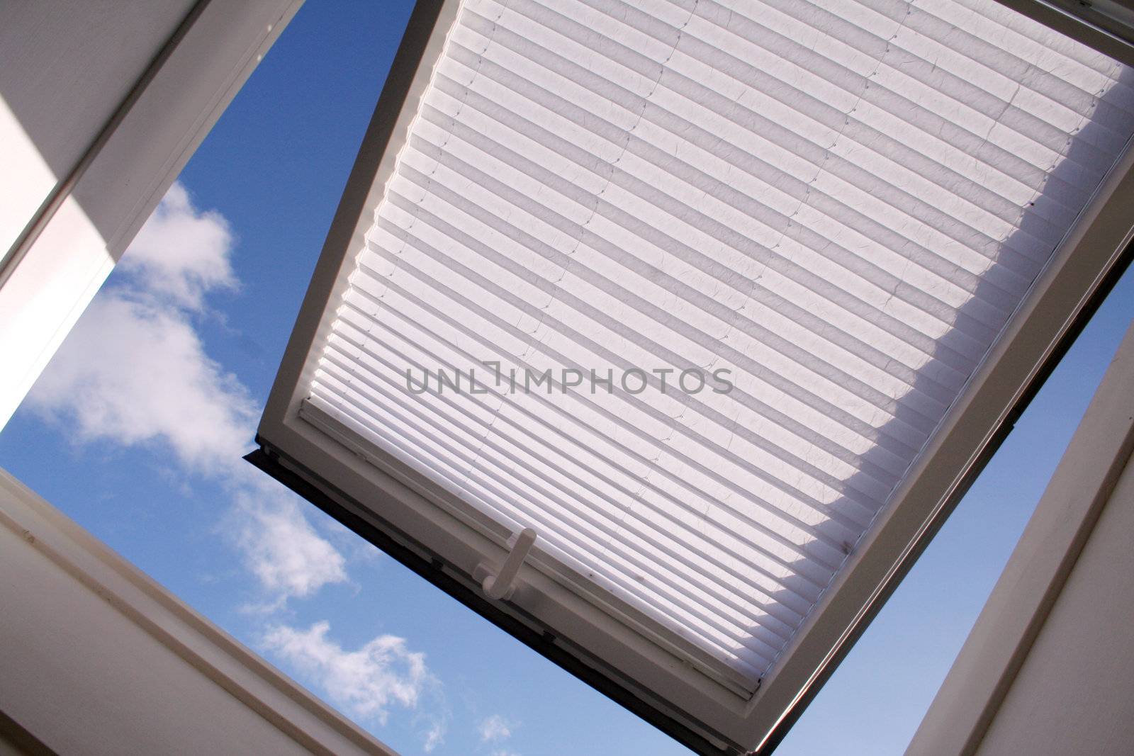 opened roof window with shutter and clouds