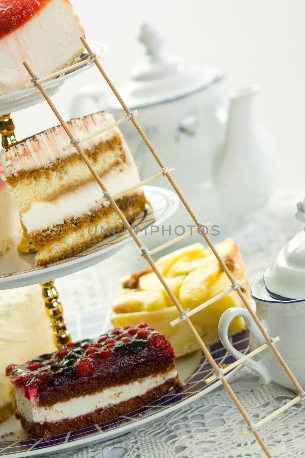 Vase with a cake, teapot and sugar are on the table