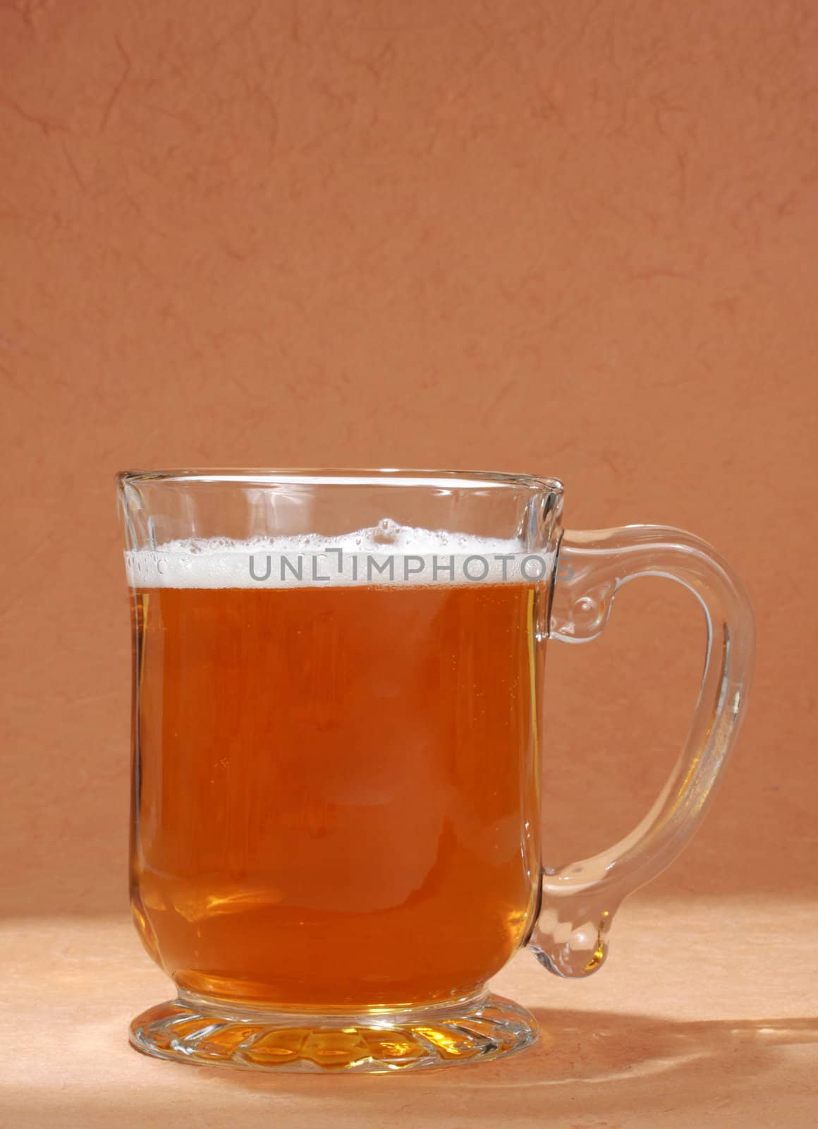 mug filled with beer, brown background