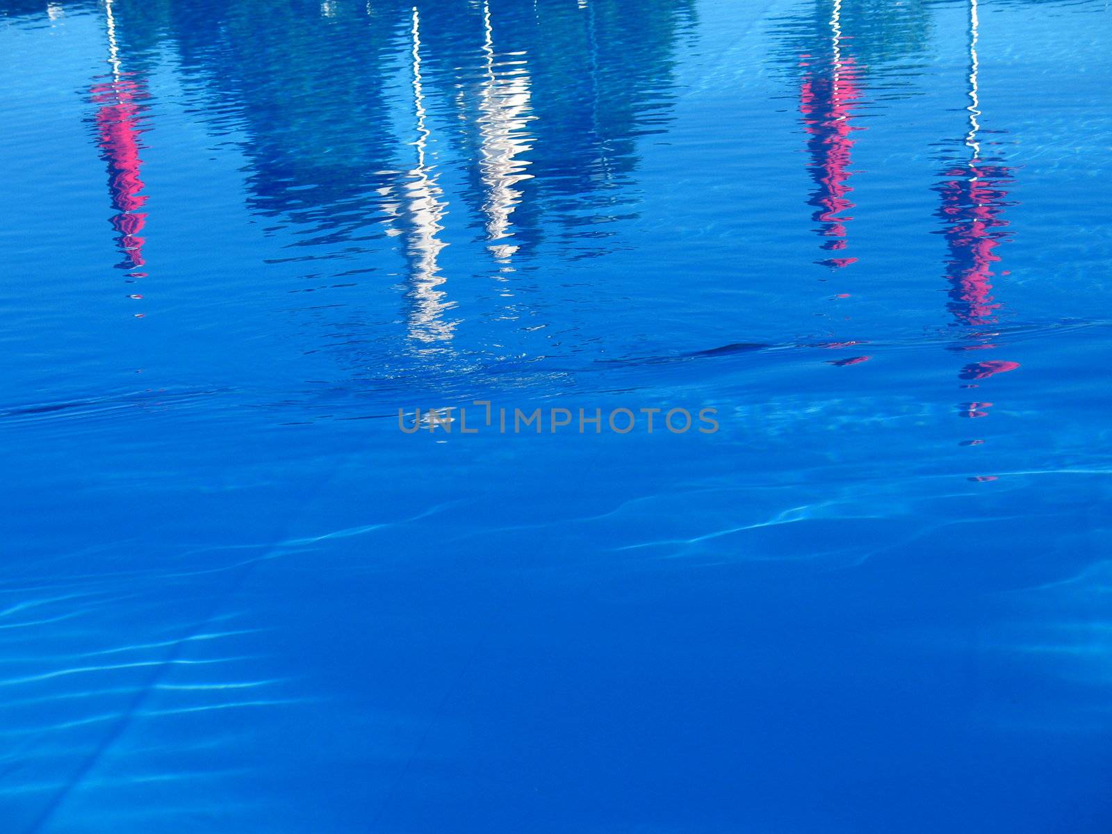 red and white umbrellas reflected in pool water