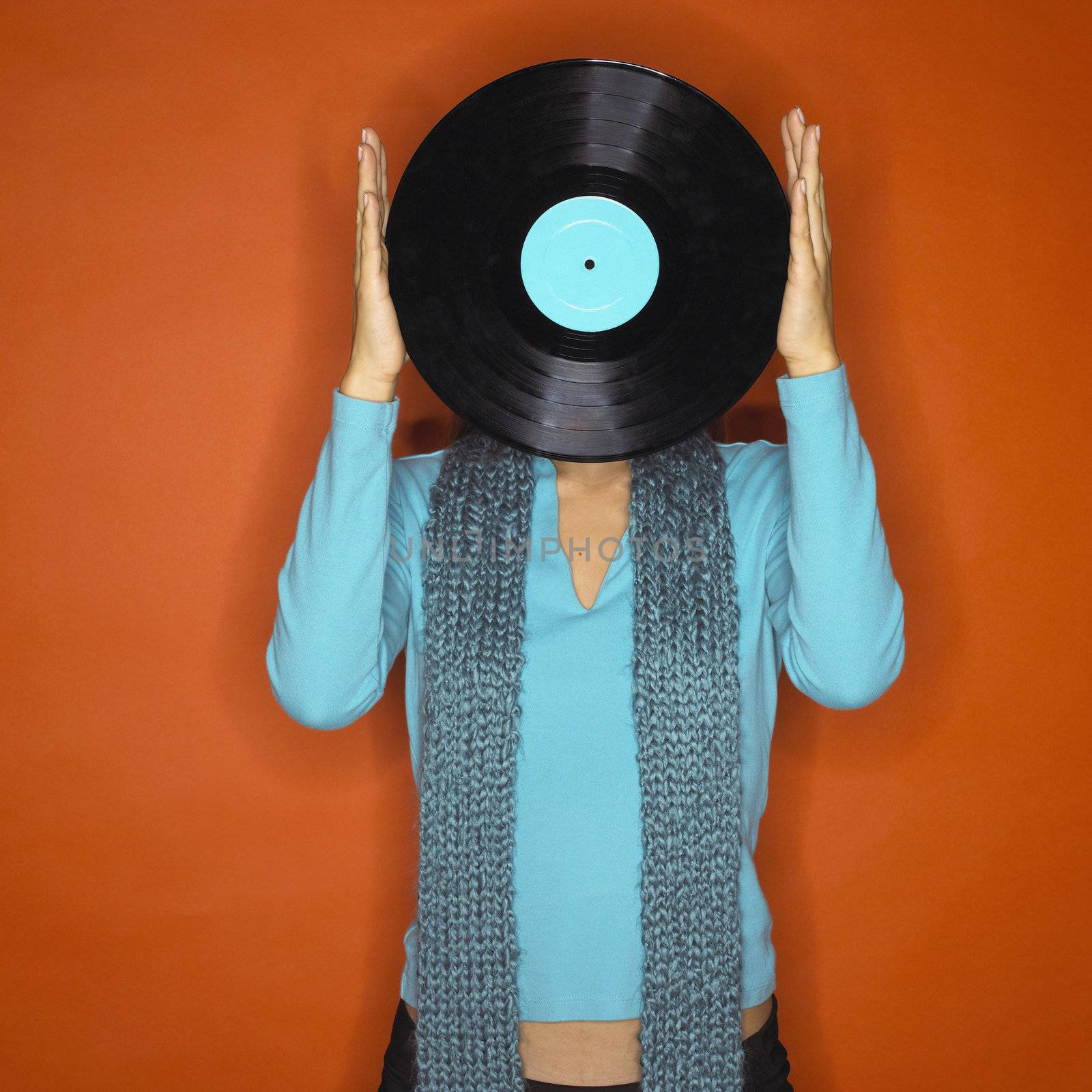 Portrait of Young Woman Holding Up Record in Front of Face