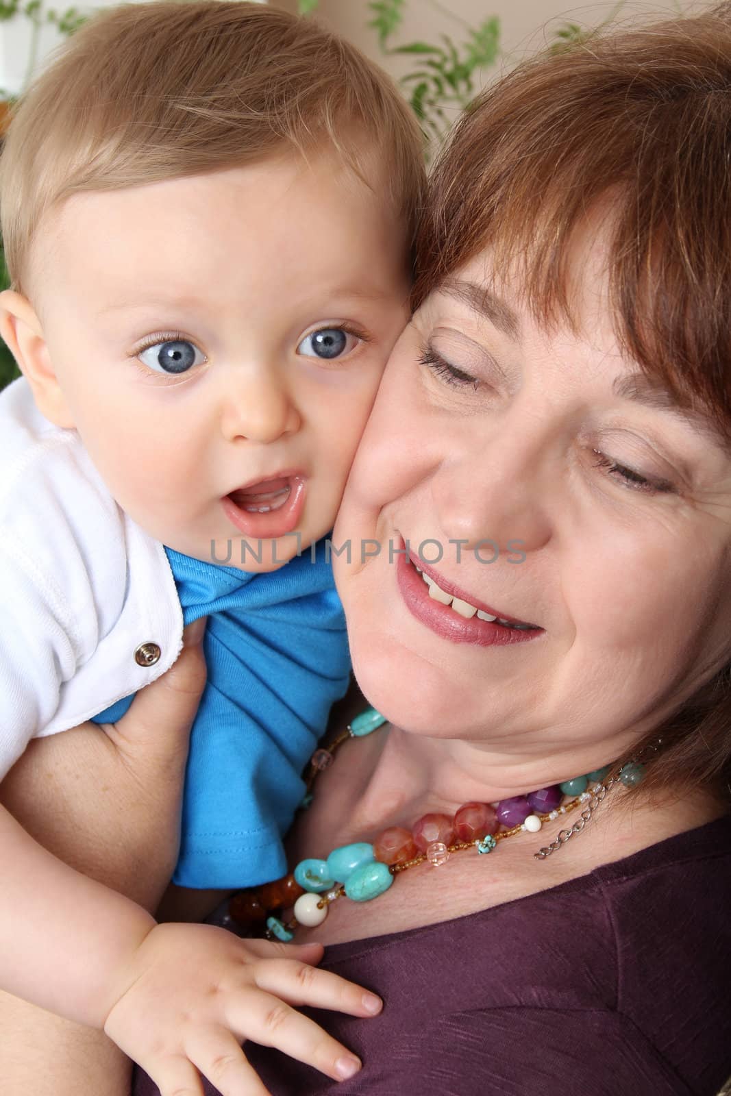 Beautiful blond baby boy sitting by his grandmother