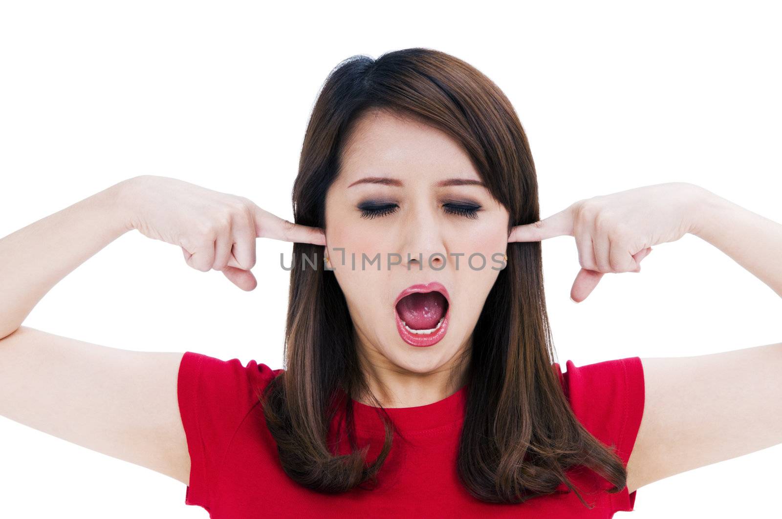 Portrait of a frustrated young woman with fingers in her ears, isolated on white background.