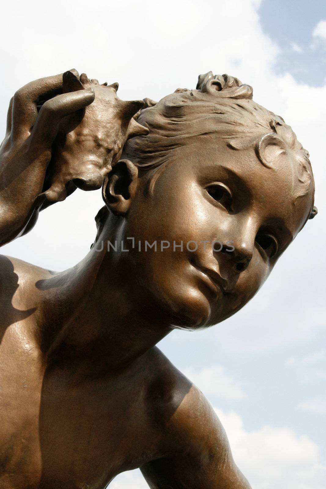 Statue of mythological young boy listening carefully on the Alexander III bridge in Paris