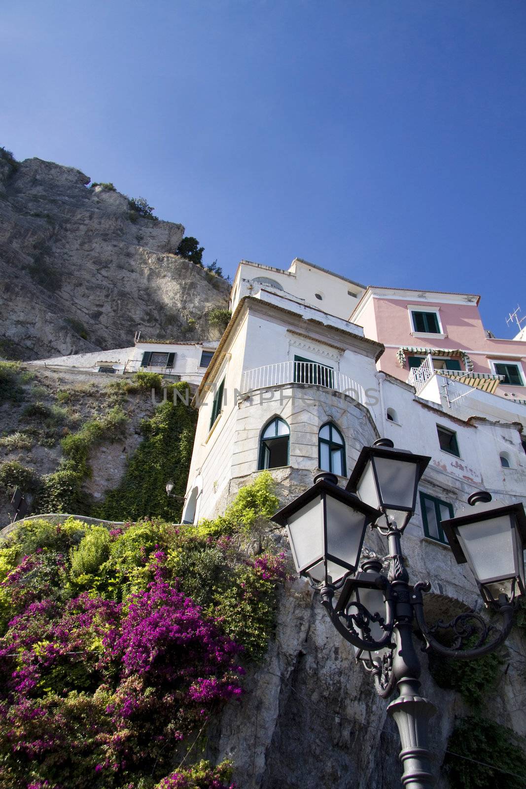 Houses on the cliff with flowers at the Amalfi coast in Italy