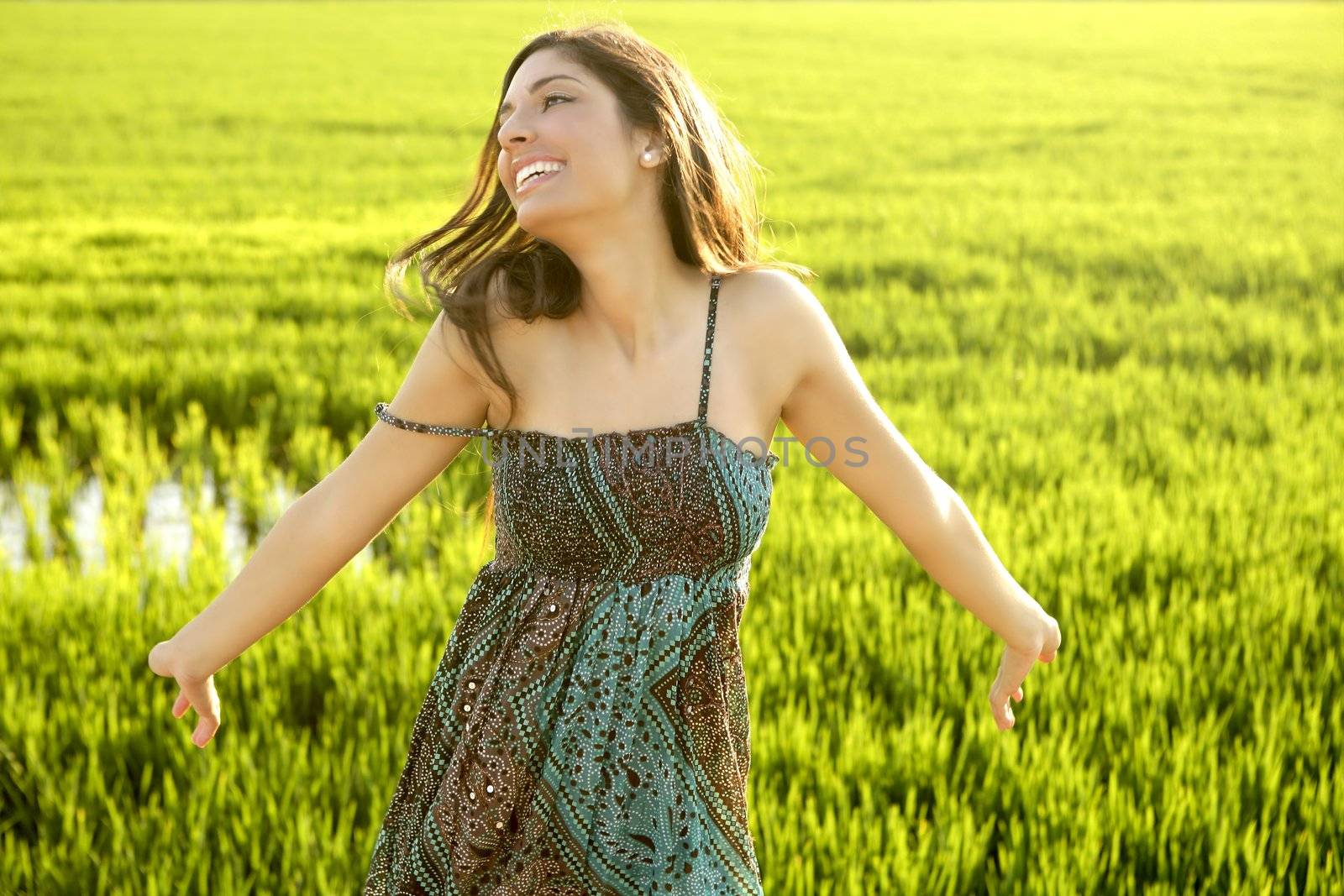 Beautiful brunette indian woman in green rice fields by lunamarina