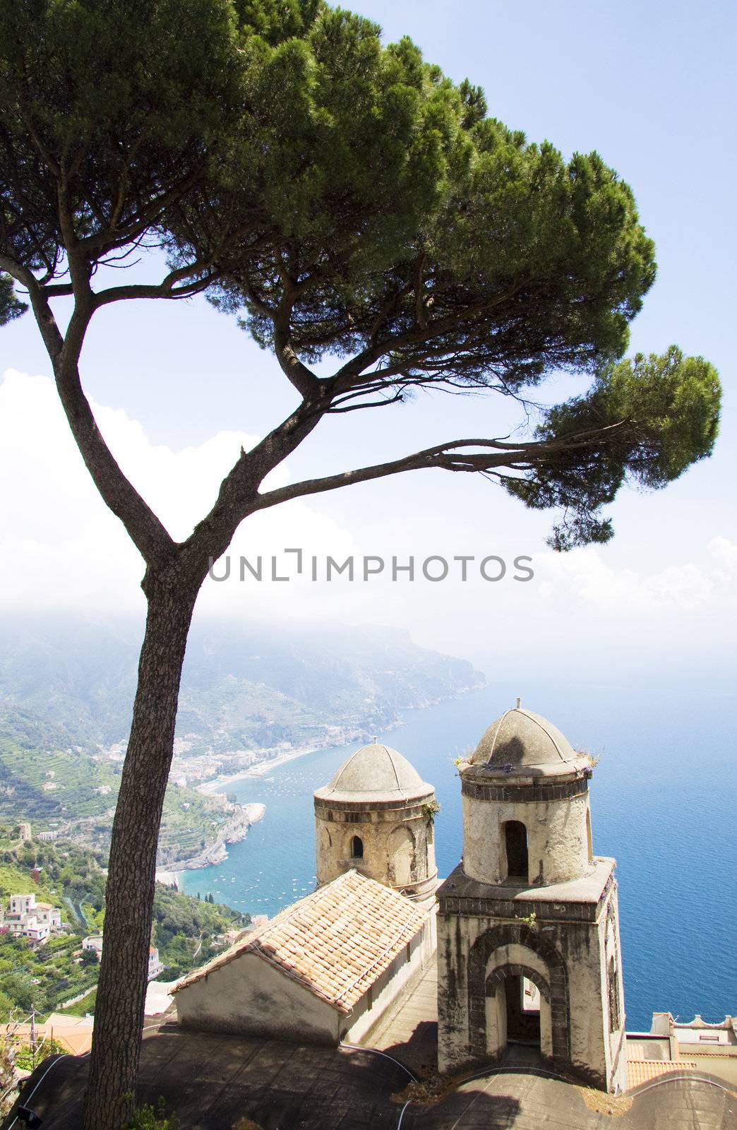 The Ravello garden offers a view of the two church towers, a tree and the Amalfi coast