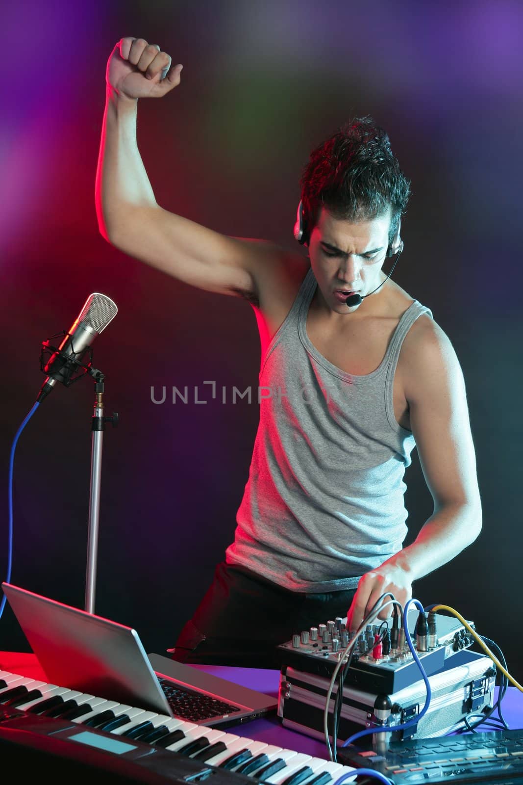 Dj with colorful light and music mixing digital equipment